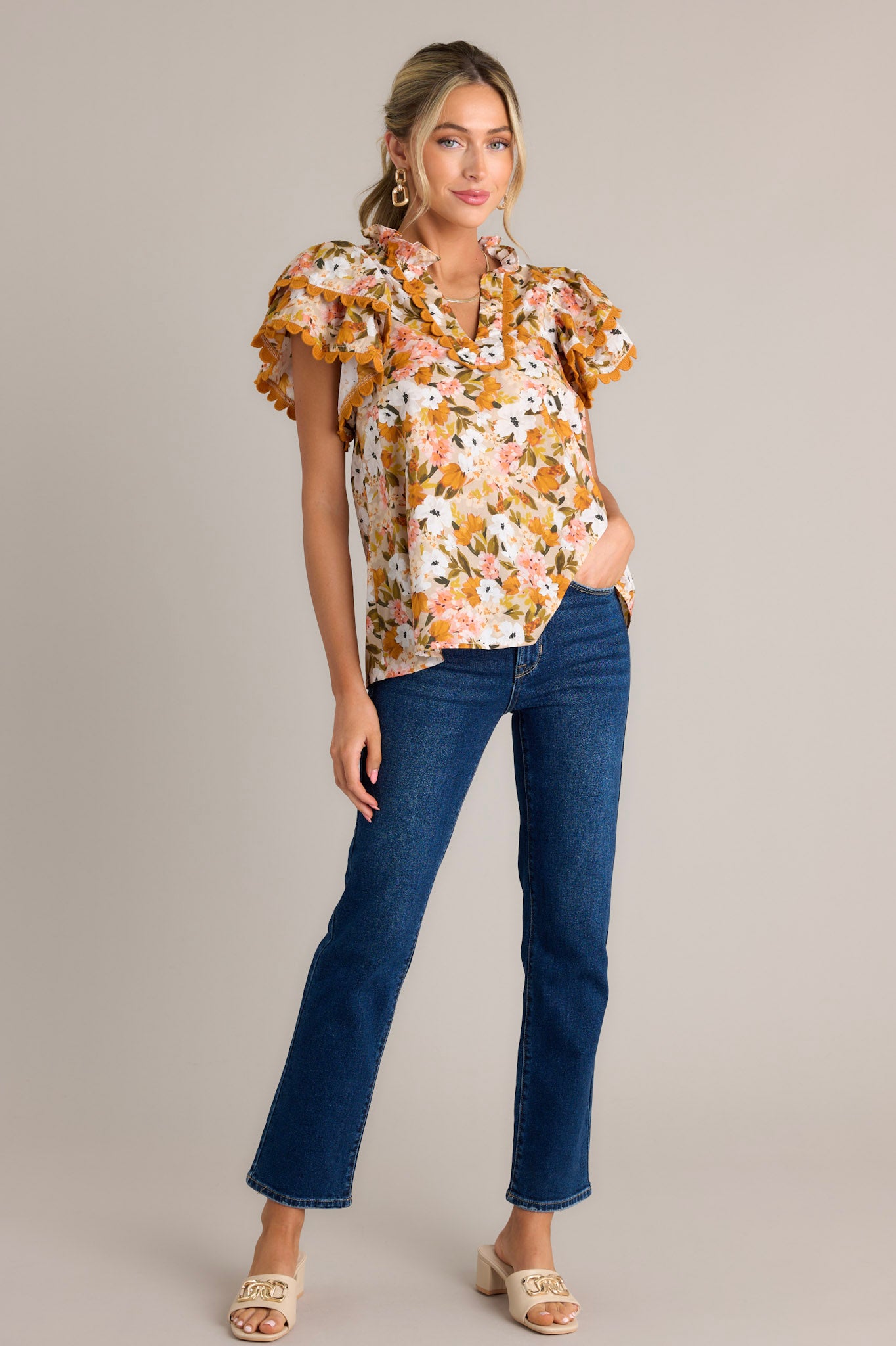 Full length view of a yellow top with a ruffled v-neckline, scalloped detailing, a lightweight material, and layered scalloped short sleeves