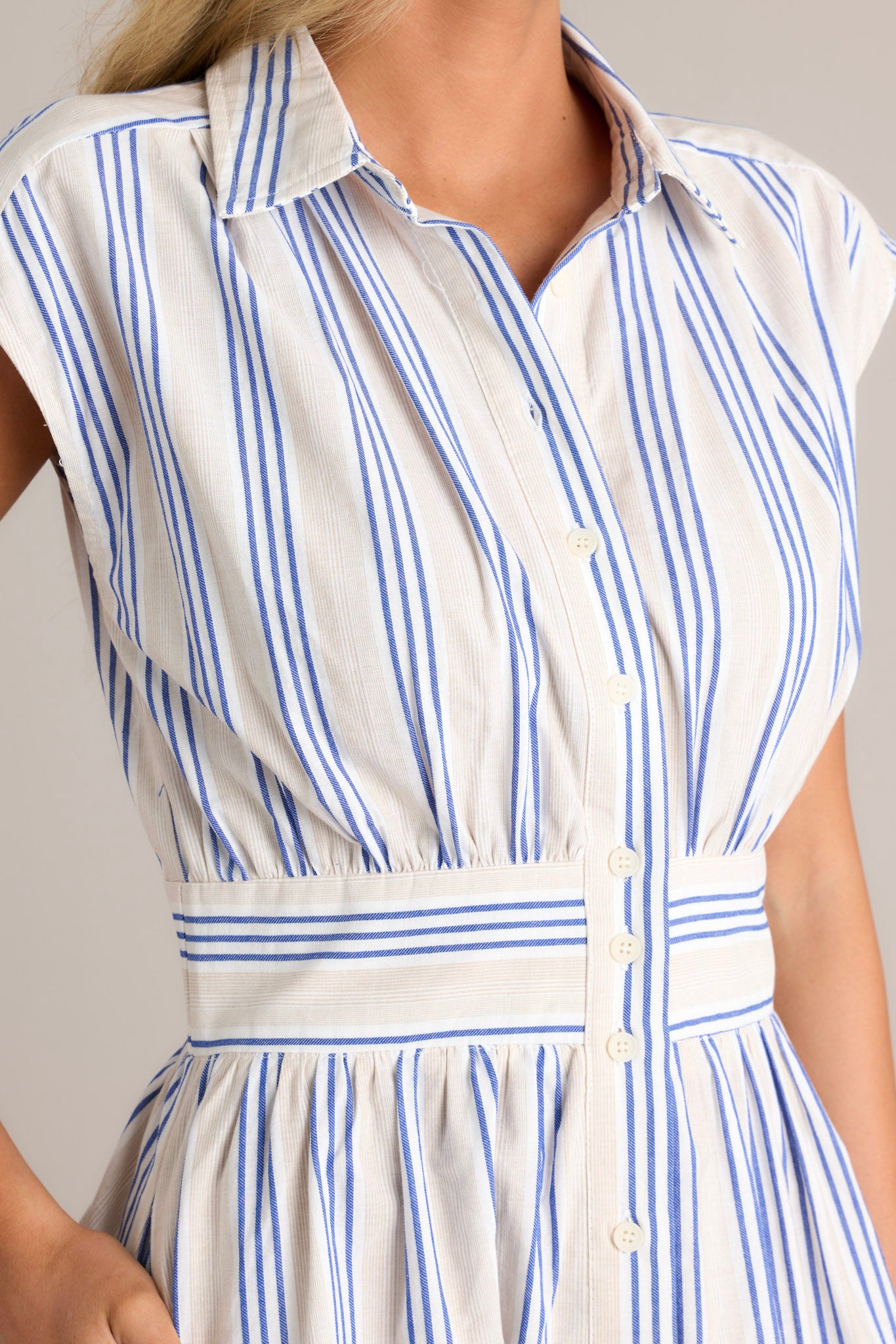 Close-up of the blue stripe midi dress showing the collared neckline, functional button front, and beige and blue stripe pattern.