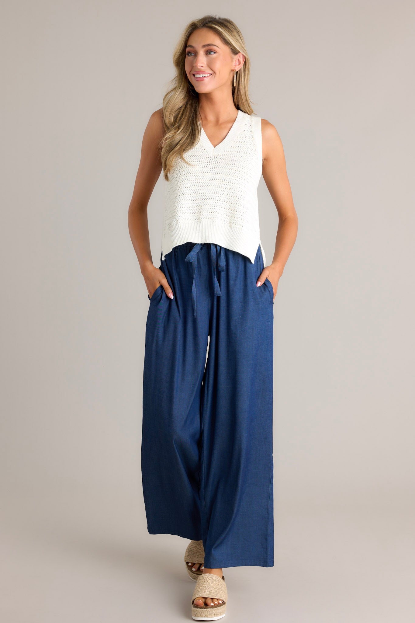 Full length view of an ivory top with a v-neckline, a cropped length, and a knit texture throughout