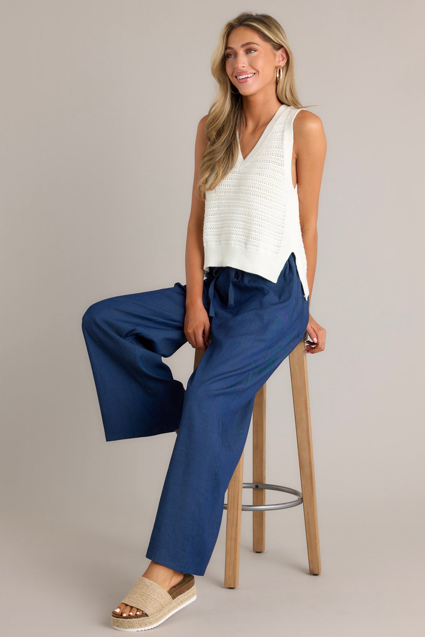 These dark chambray pants feature a high waisted design, an elastic waistband, a self-tie drawstring, functional hip pockets, and a wide leg.