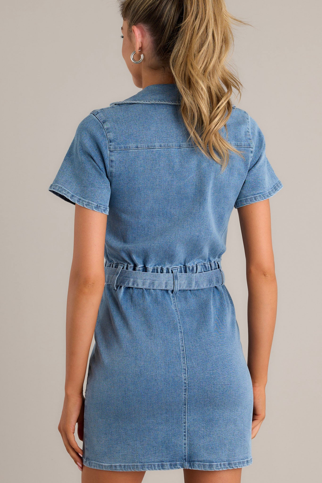 Back view of a chambray mini dress highlighting the elastic waist insert and overall fit.