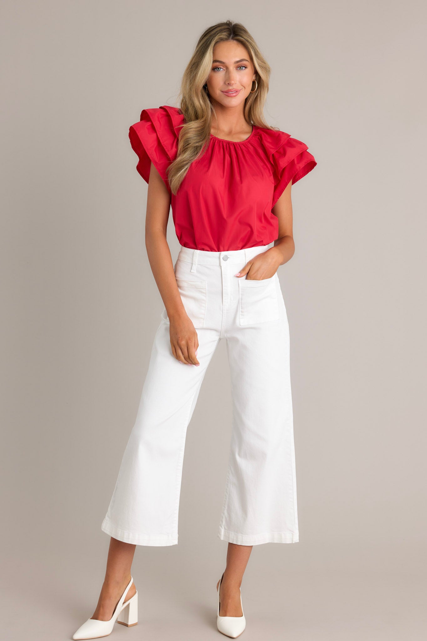Full length view of a red top with a rounded neckline, gathering at the neckline, a keyhole with a button closure, and ruffled short sleeves