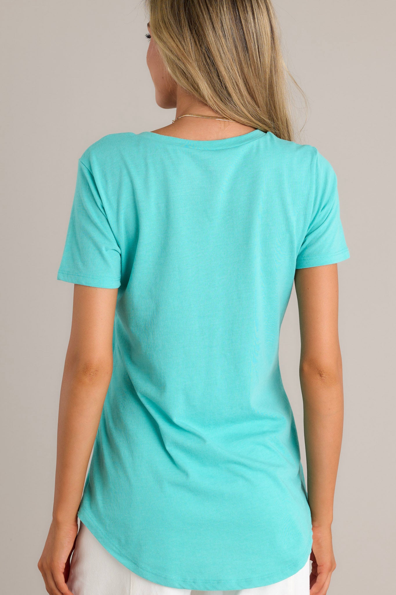 Back view of a cabana green tee highlighting the super soft fabric and scooped hemline.