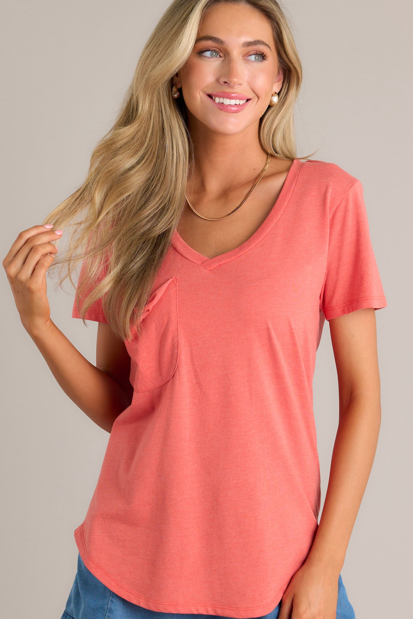 Action shot of a tee displaying the fit and movement, highlighting the v-neckline, slouched breast pocket, scooped hemline, and short sleeves.