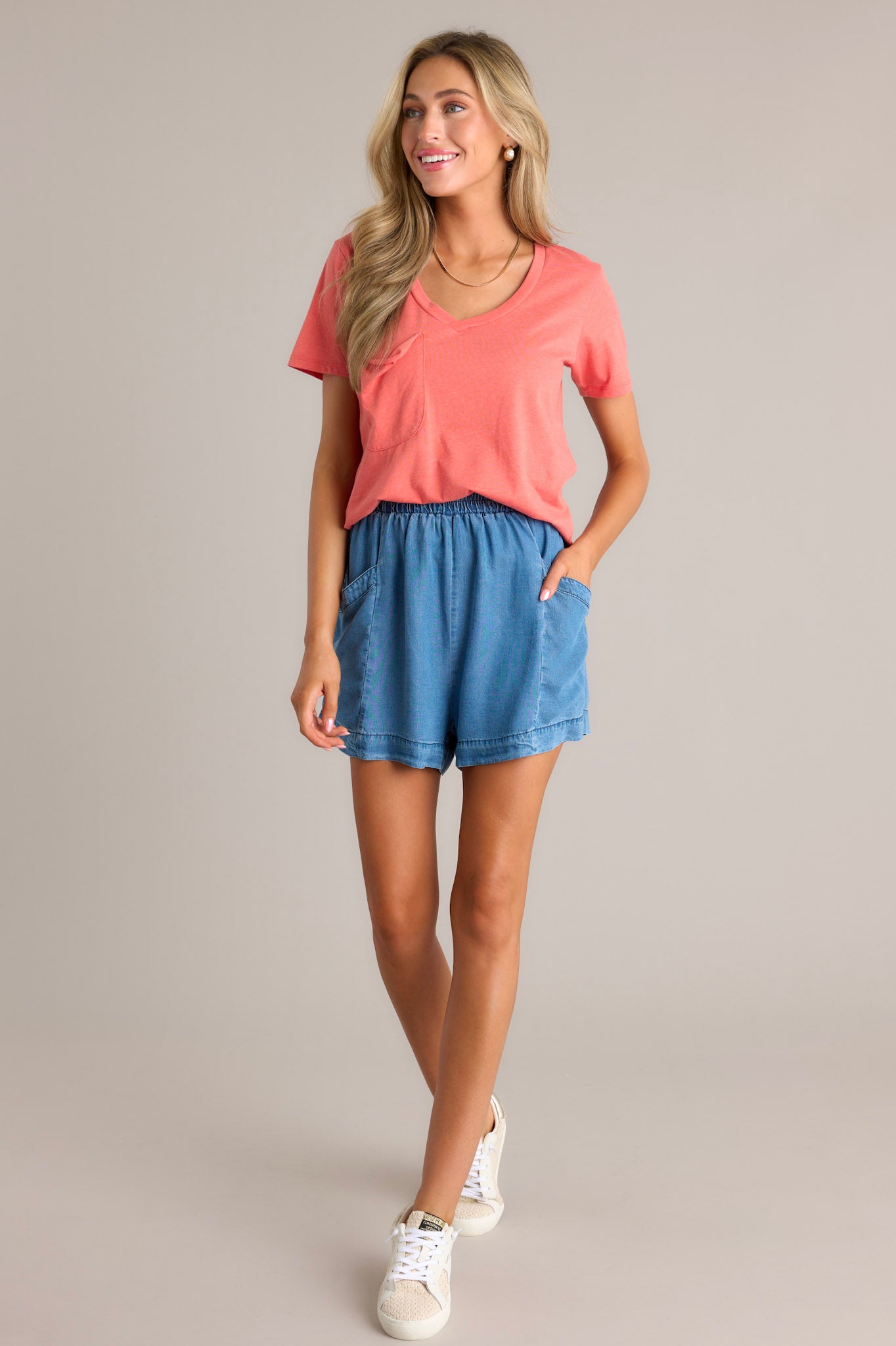 Full length view of medium chambray shorts with a high waisted design, an elastic waistband, large functional hip pockets, and a wide leg3