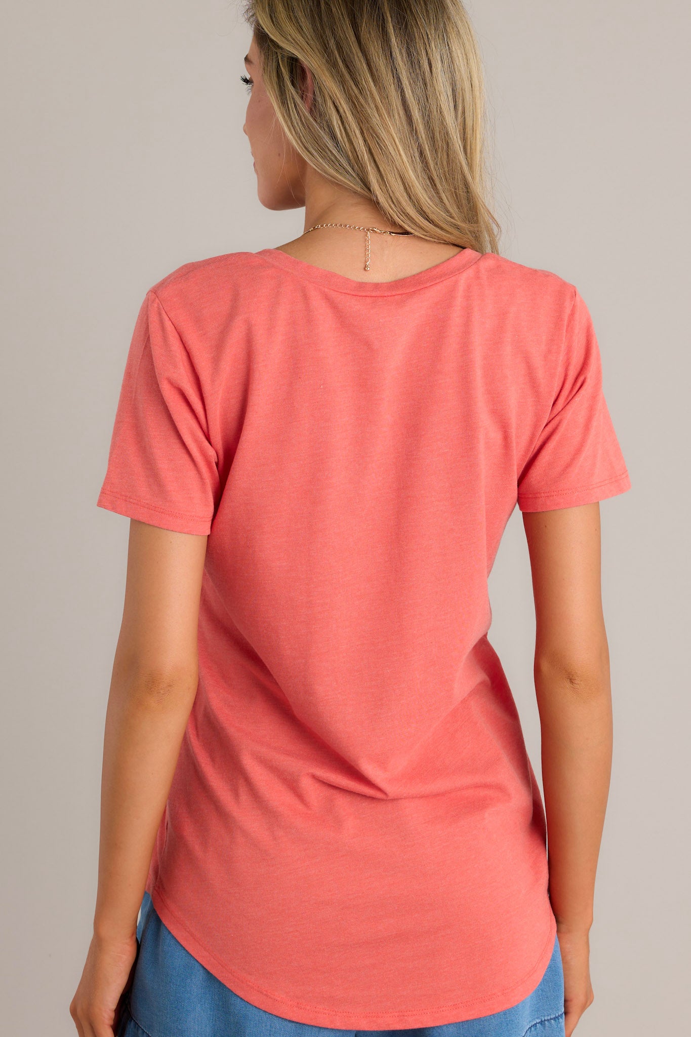 Back view of a tee highlighting the scooped hemline and the overall fit.