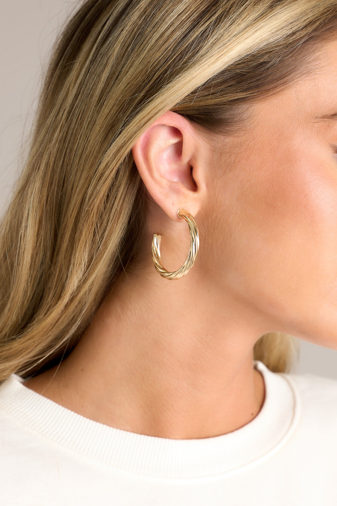 These earrings feature gold hardware, a twist like design, and a secure post backing.