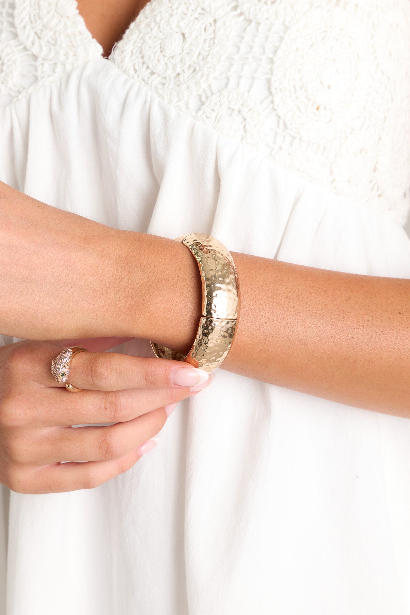 This gold bracelet features a textured material, and elastic bands underneath for stretch