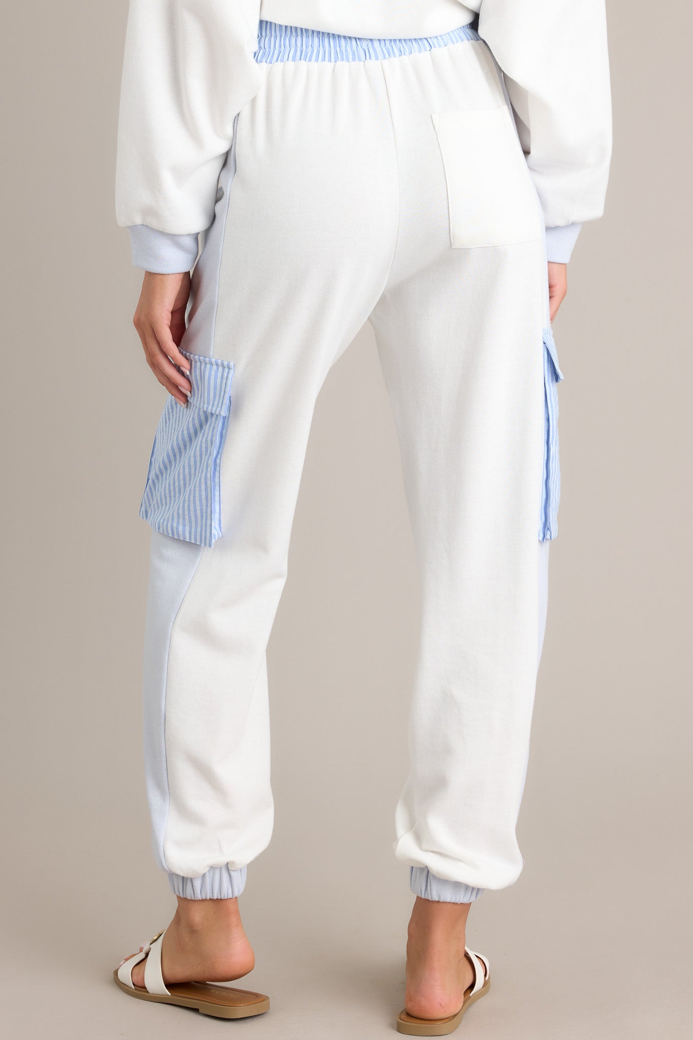 Back view of light blue joggers highlighting the functional back pocket, elastic waistband, and overall fit.