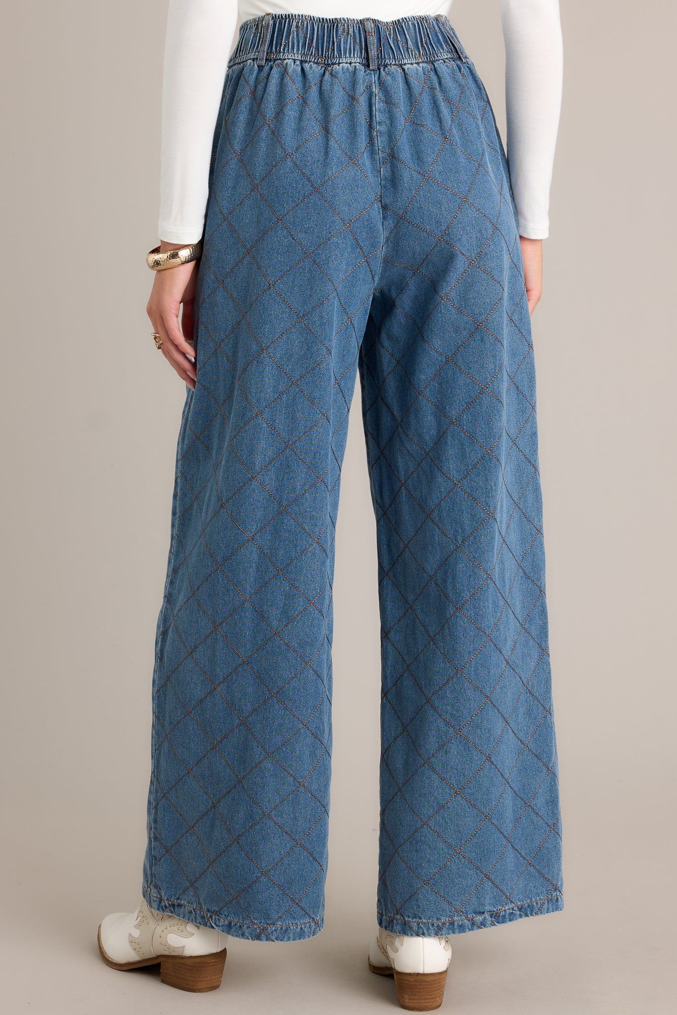 Back view of quilted jeans highlighting the overall fit, functional belt loops, and wide leg design.