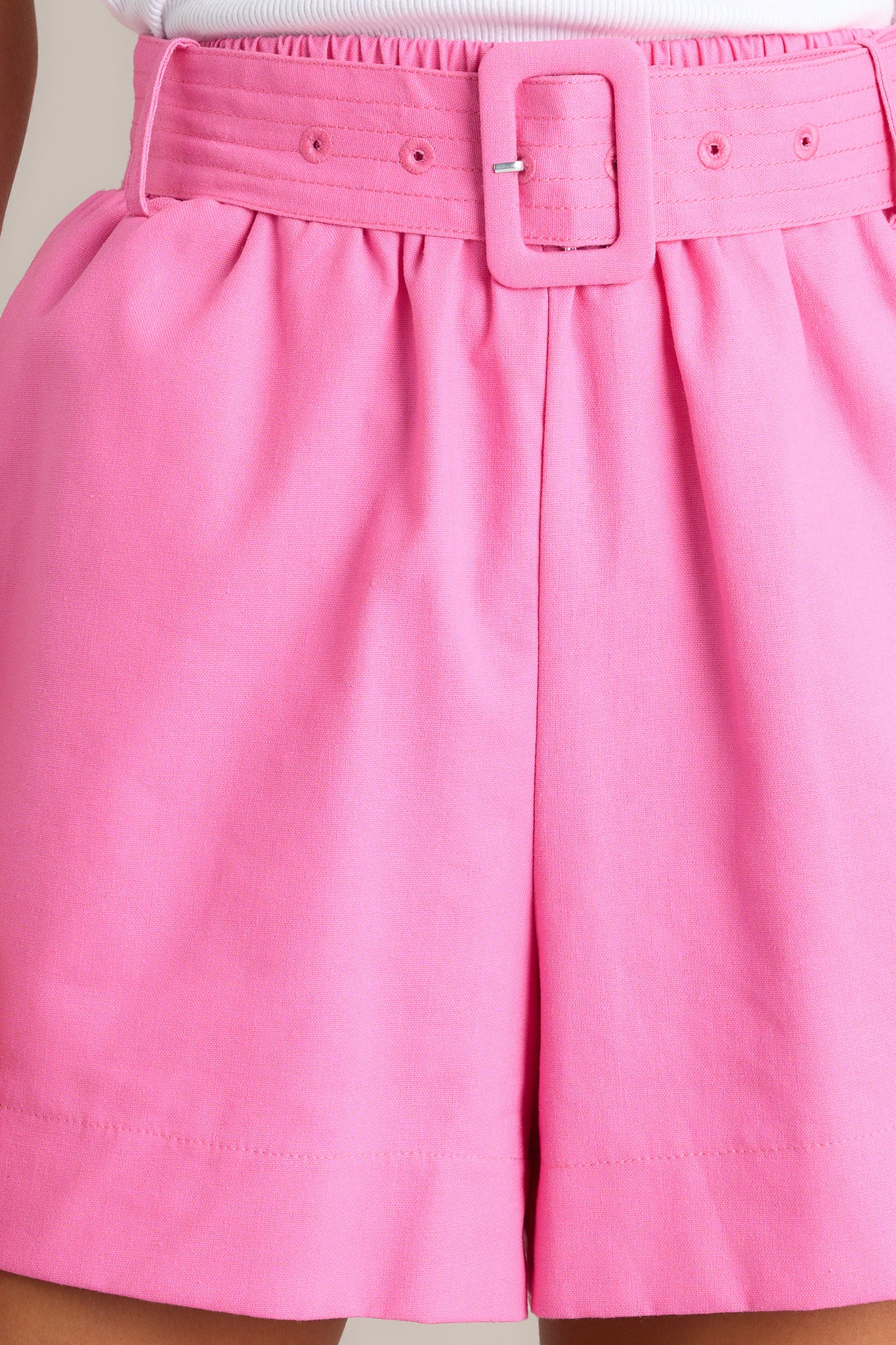 Close up view of these pink shorts, showcasing the fabric and belt details.