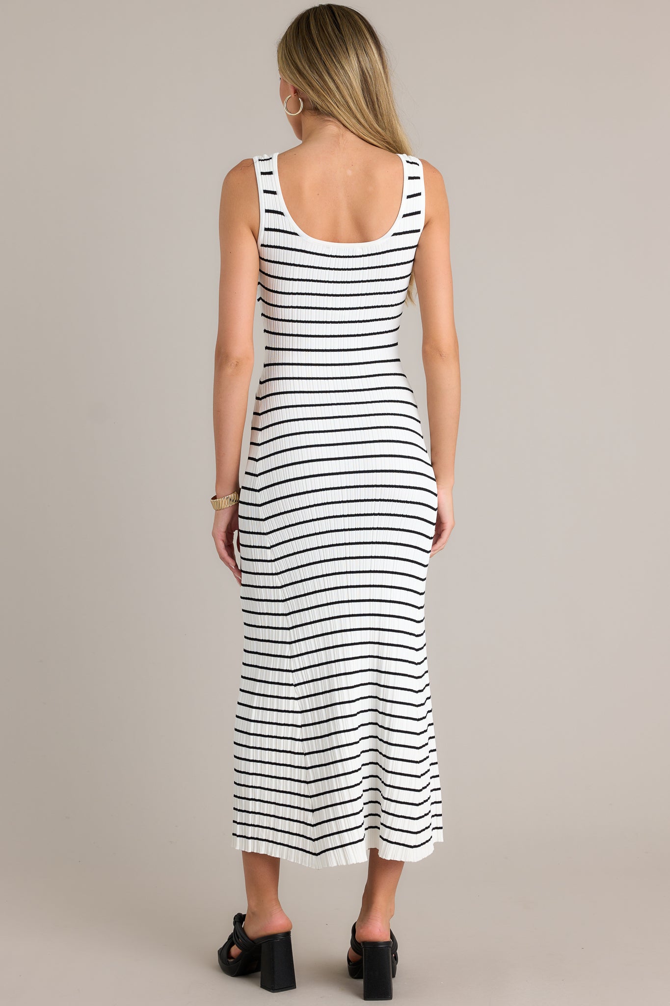 Back view of a white stripe dress highlighting the overall fit, soft ribbed texture, and classic stripe design.