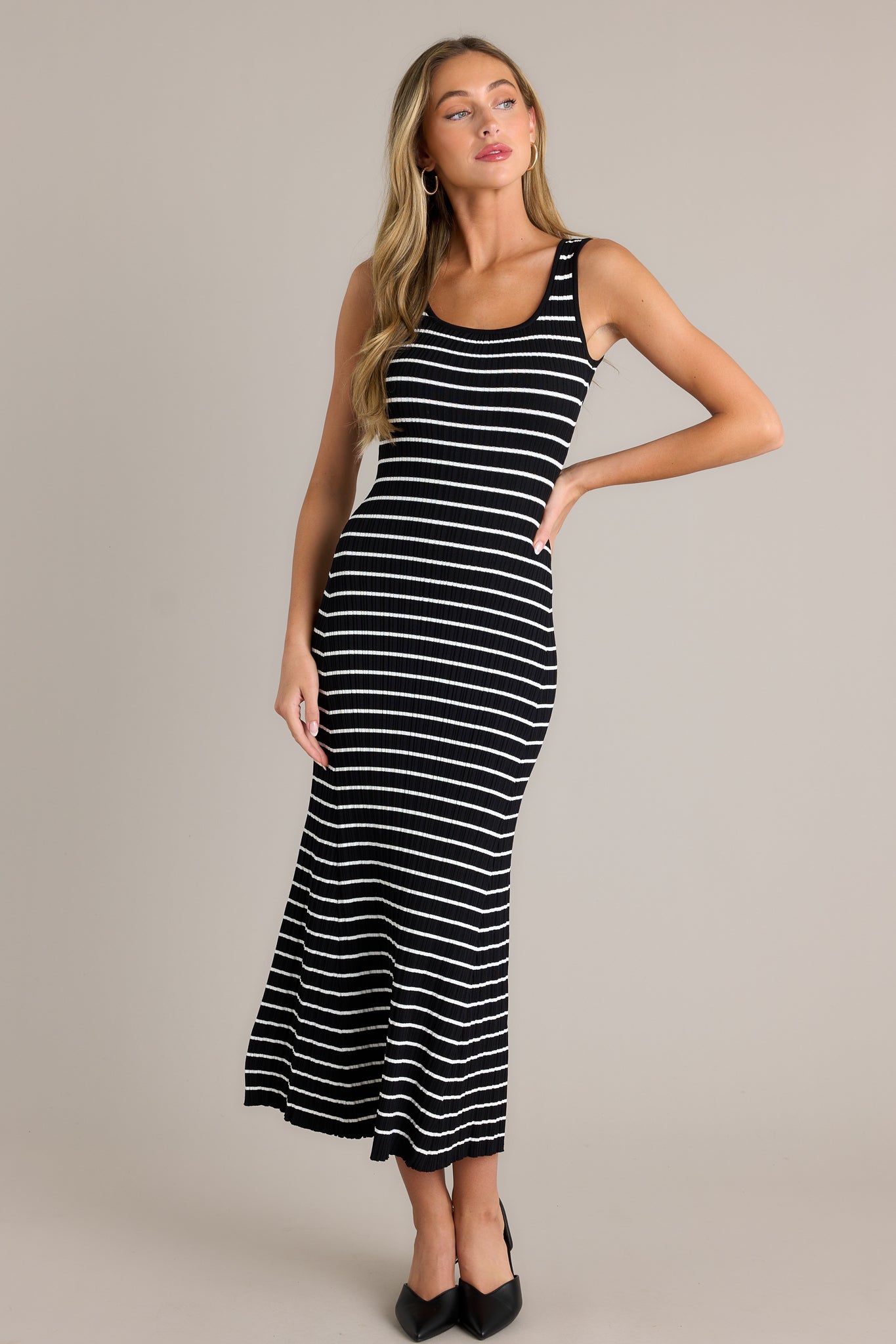 Front view of a black stripe dress featuring a scoop neckline, a classic stripe design, a soft ribbed texture, and a bodycon fit.