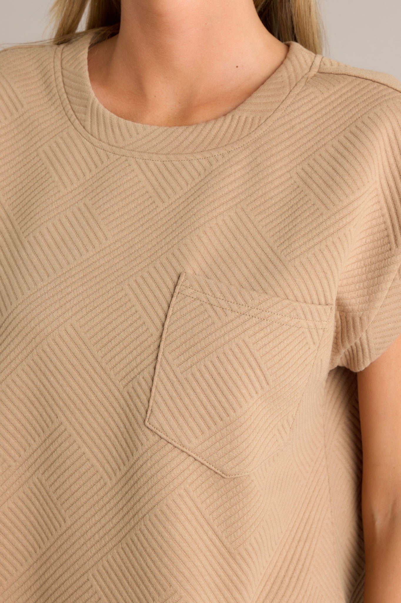 Close-up detail of the crisscross texturing on the tan top, focusing on the functional breast pocket.