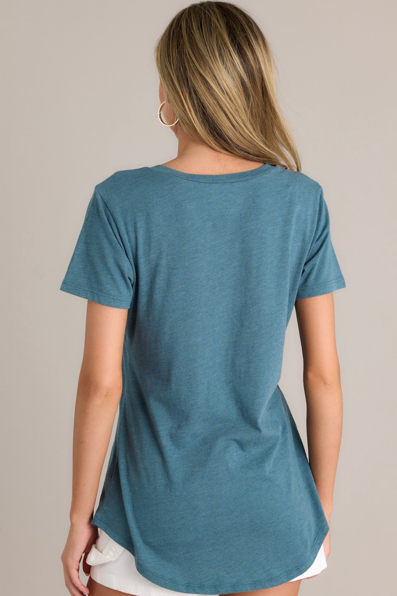 Back view of a dragonfly green tee highlighting the super soft fabric and scooped hemline.