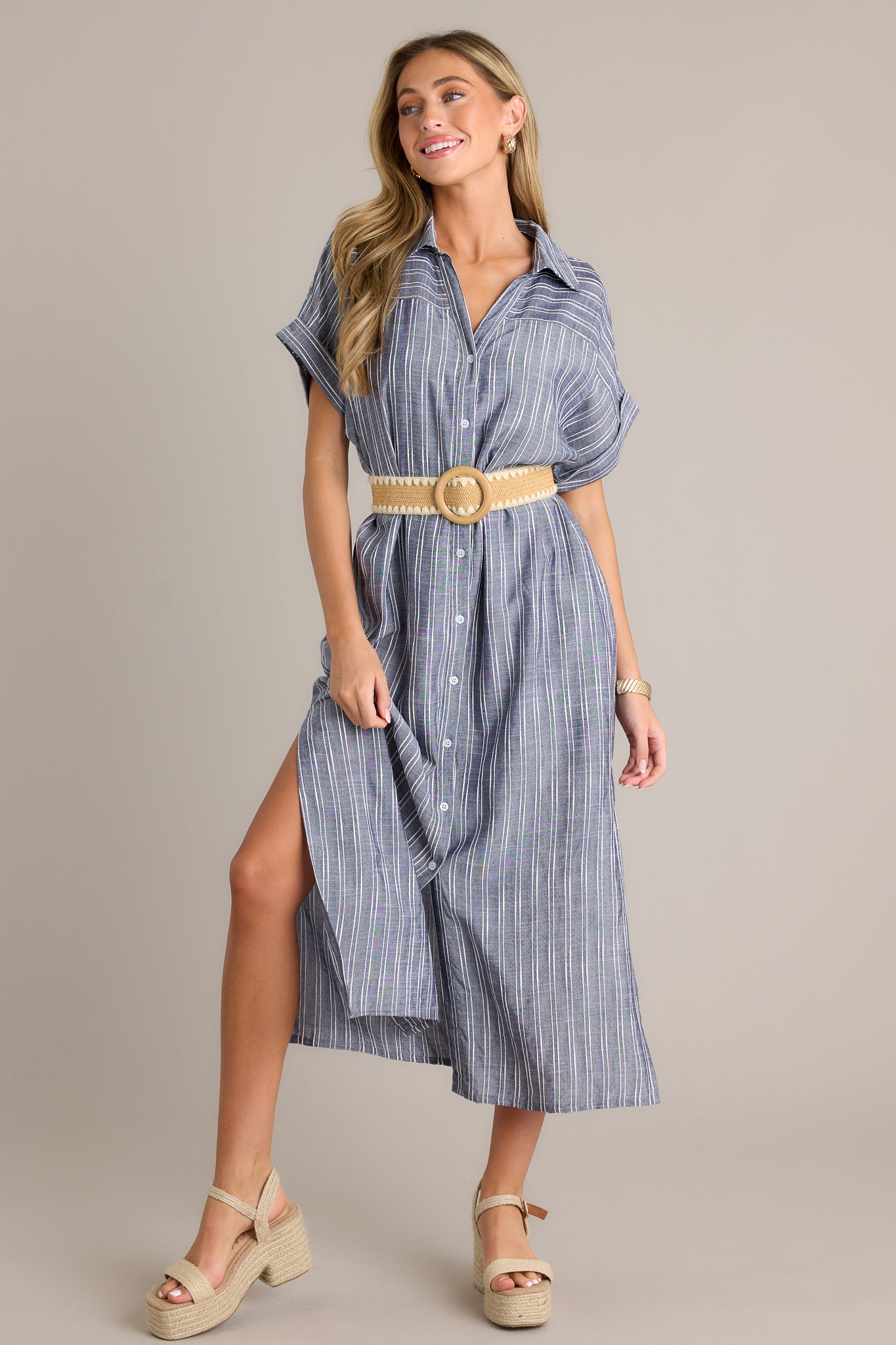 Front angled view of a blue dress featuring a functional button front, an optional self-tie belt, a collared neckline, and cuffed short sleeves