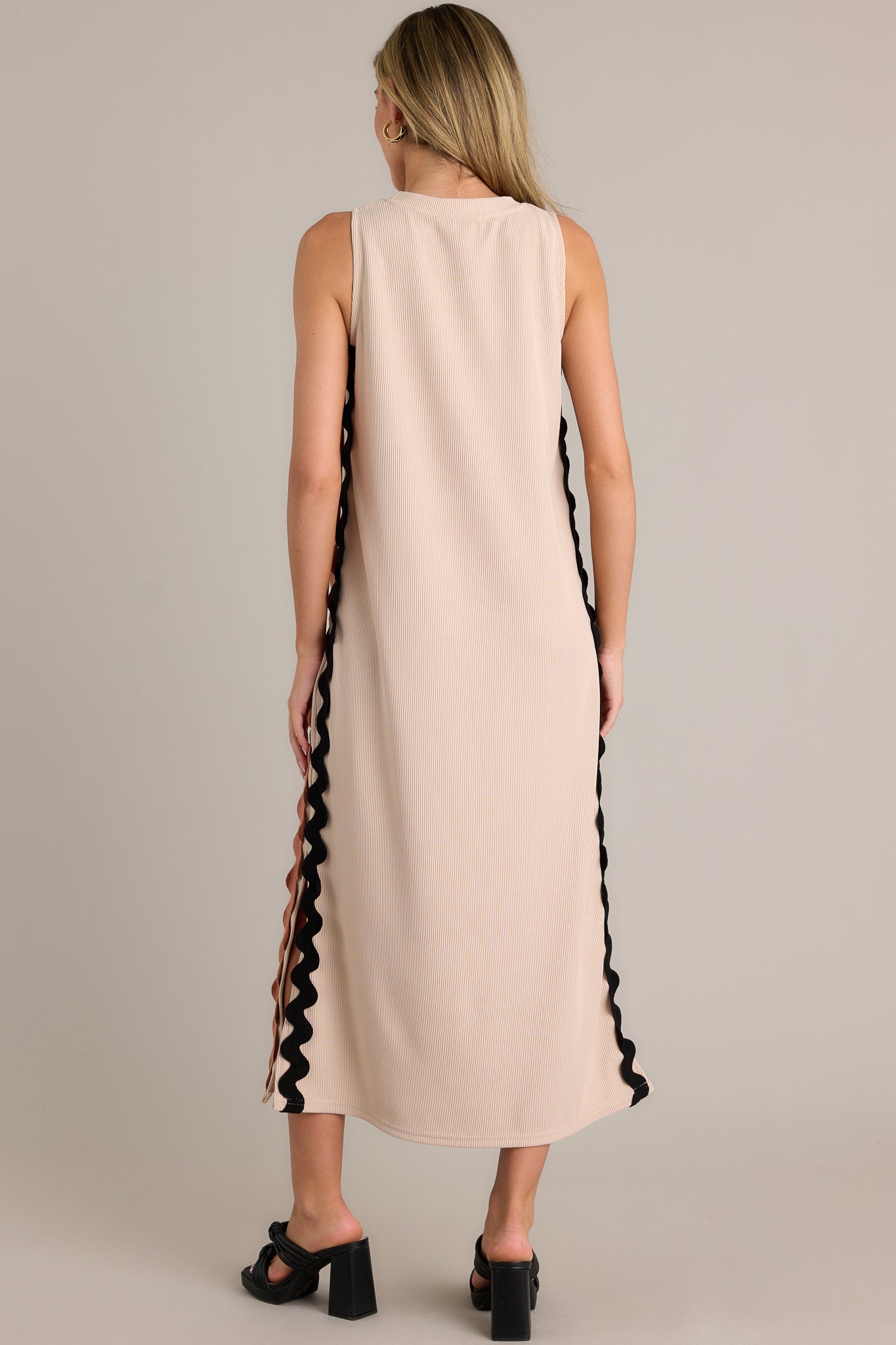 Back view of a taupe midi dress highlighting the overall fit, ribbed material, and sleeveless design.