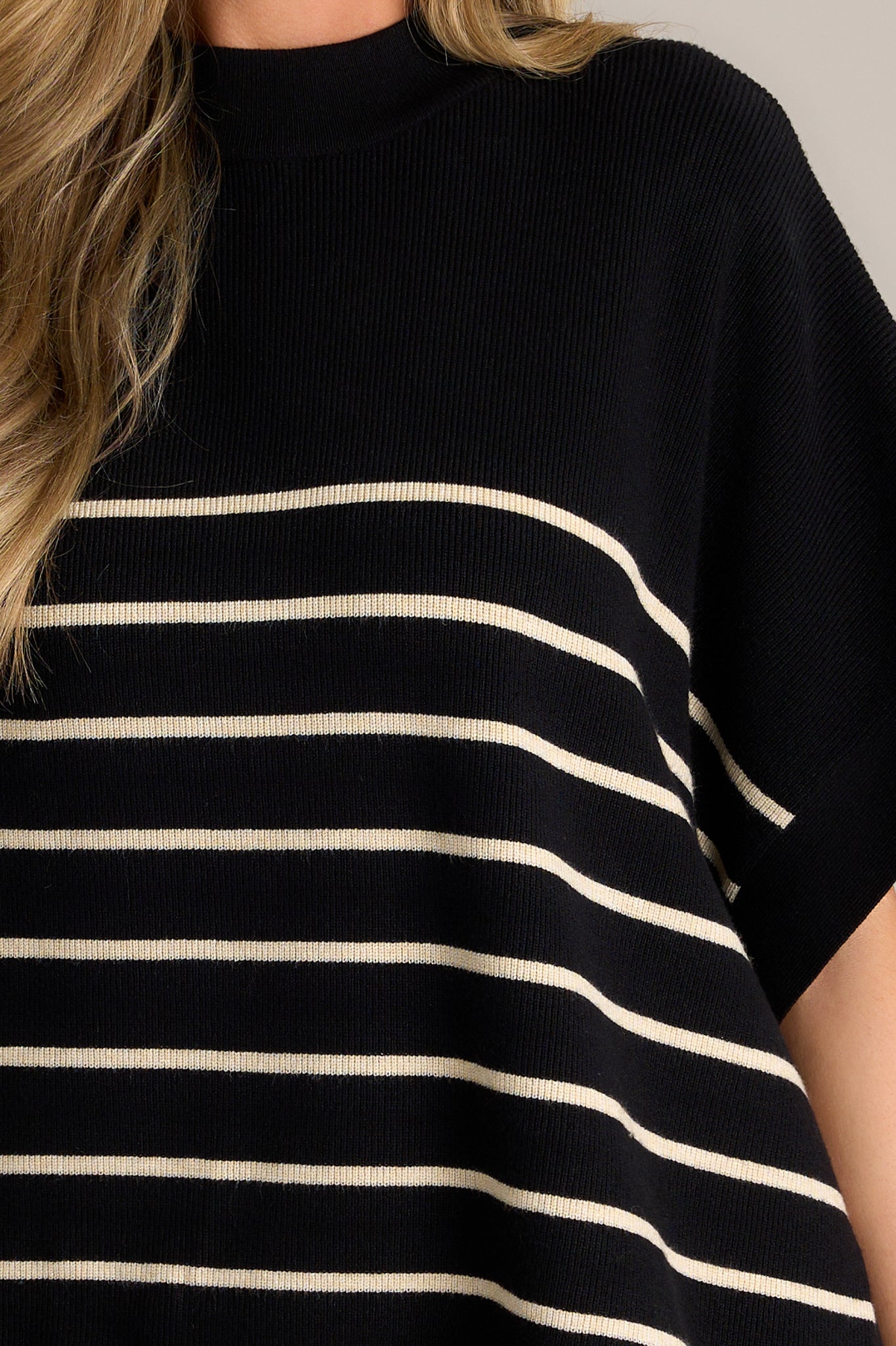 Close-up of the stripe poncho top showing the high neckline, classic stripe design, thick hem, and high side slits.