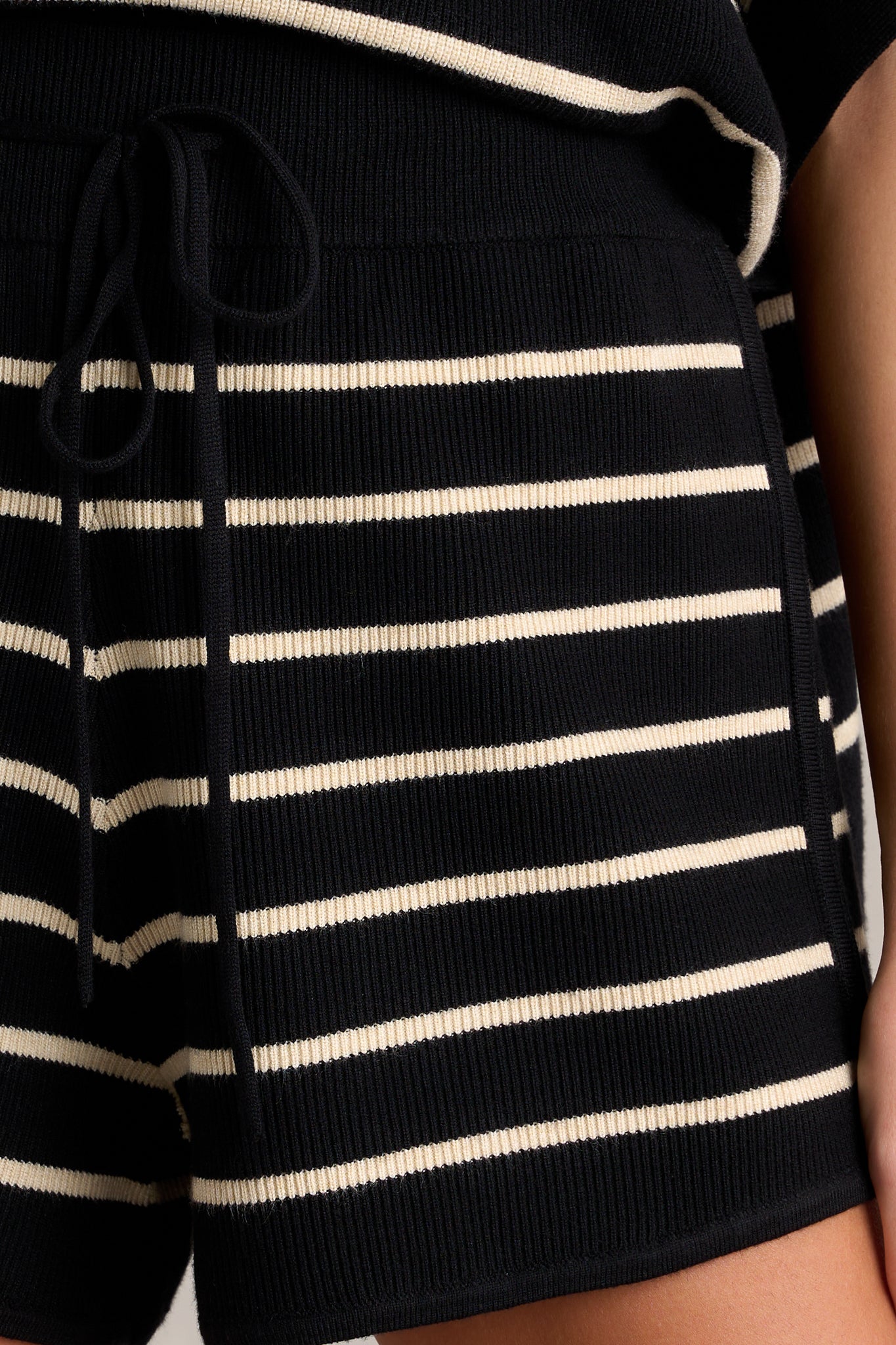 Close-up of the knit stripe shorts showing the elastic waistband, waist drawstring, and classic horizontal stripe design.