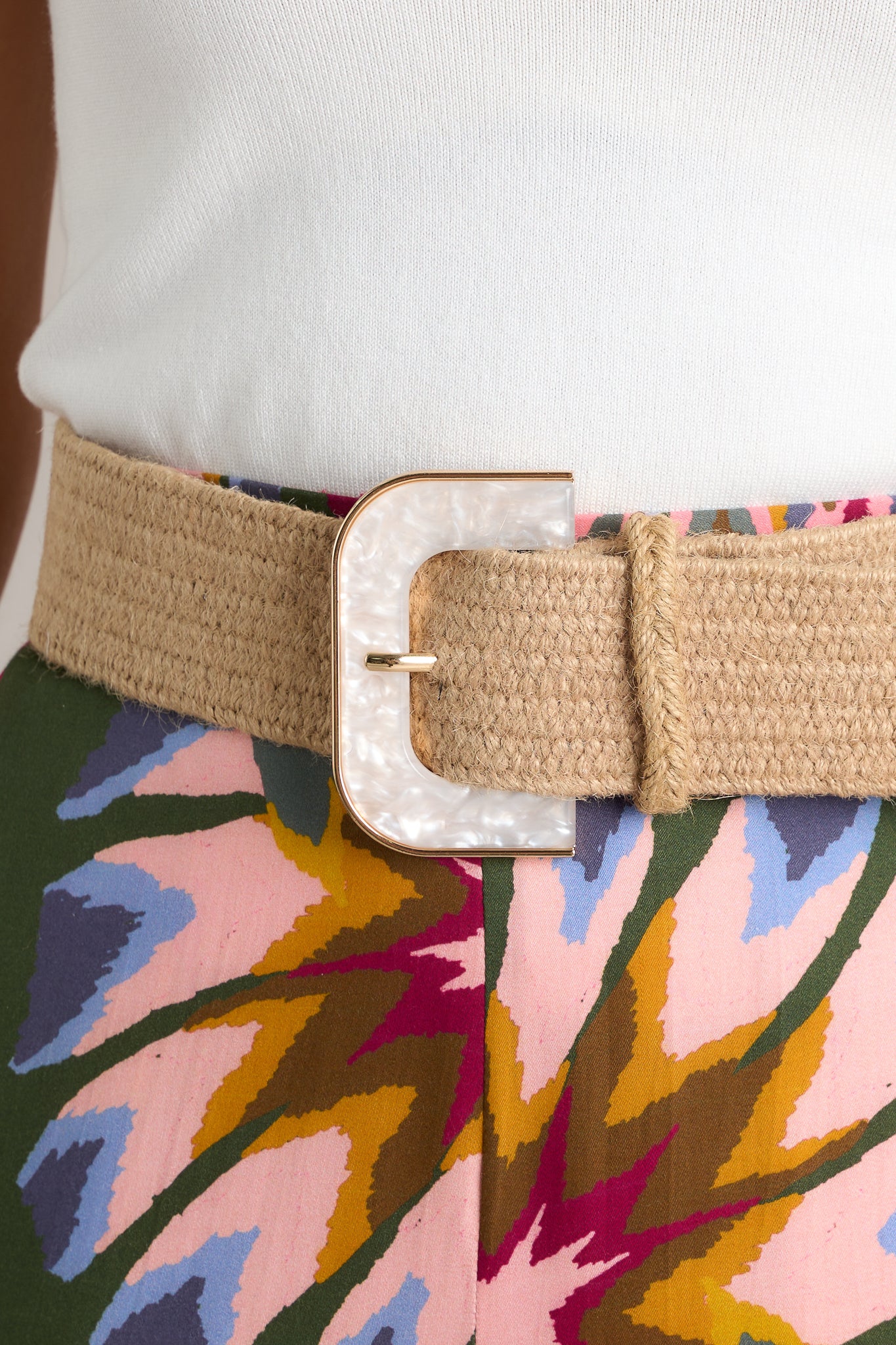 Front view of this tan belt that features a distinctive d-shaped buckle, an iridescent faux marble buckle with a gold trim and a woven material.