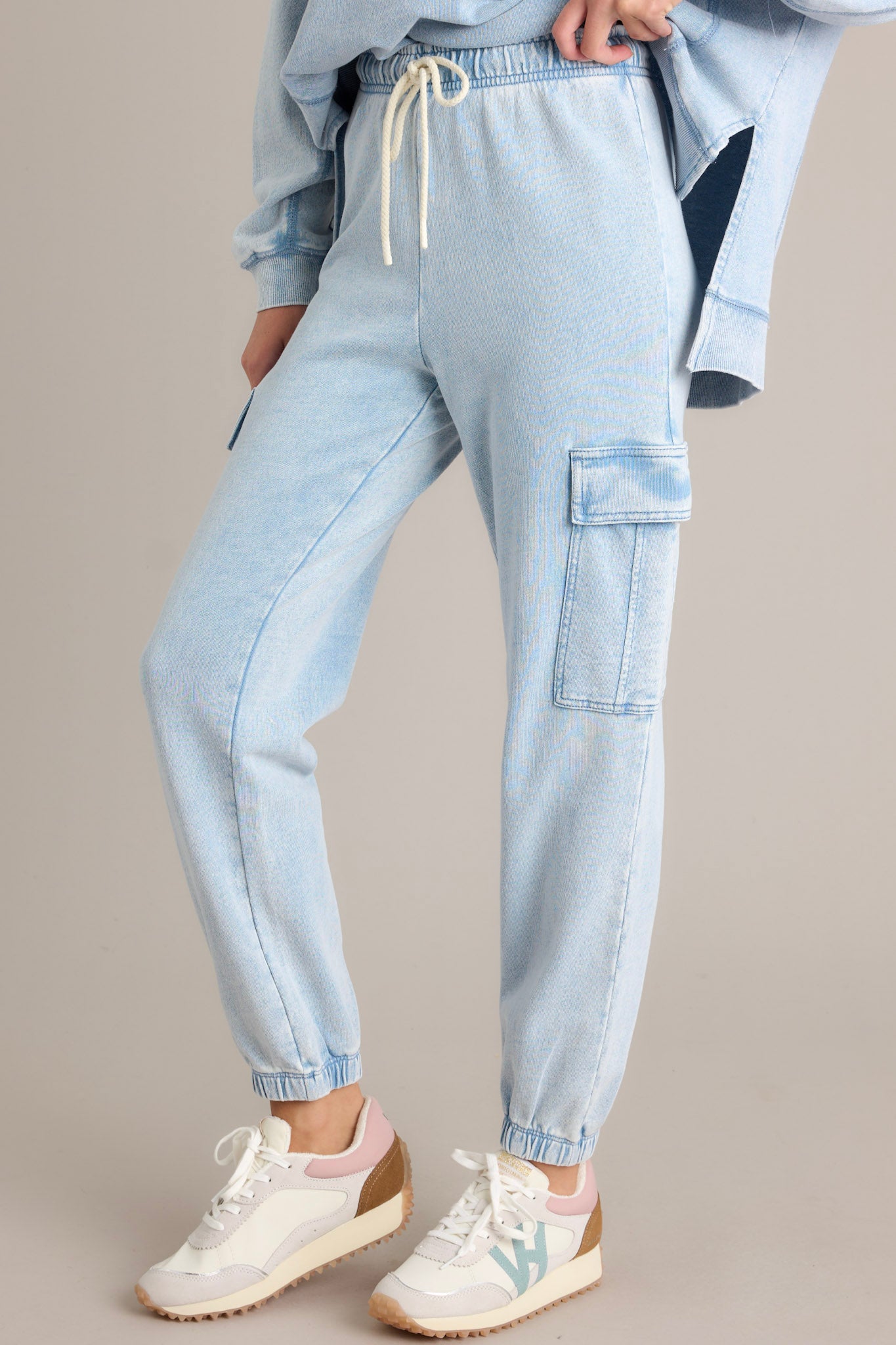 Angled view of these joggers that feature an elastic waistband with a self-tie drawstring, large side pockets, a washed design, and elastic cuffed ankles.