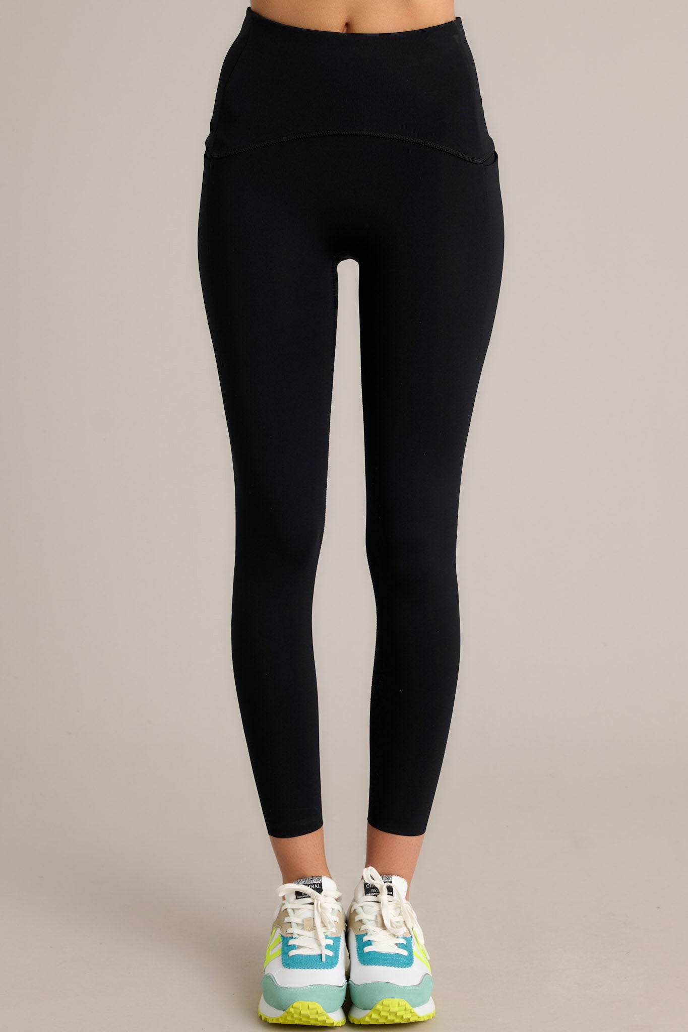 Close up  view of these black leggings that feature a high-rise contoured waistband and a hidden pocket.