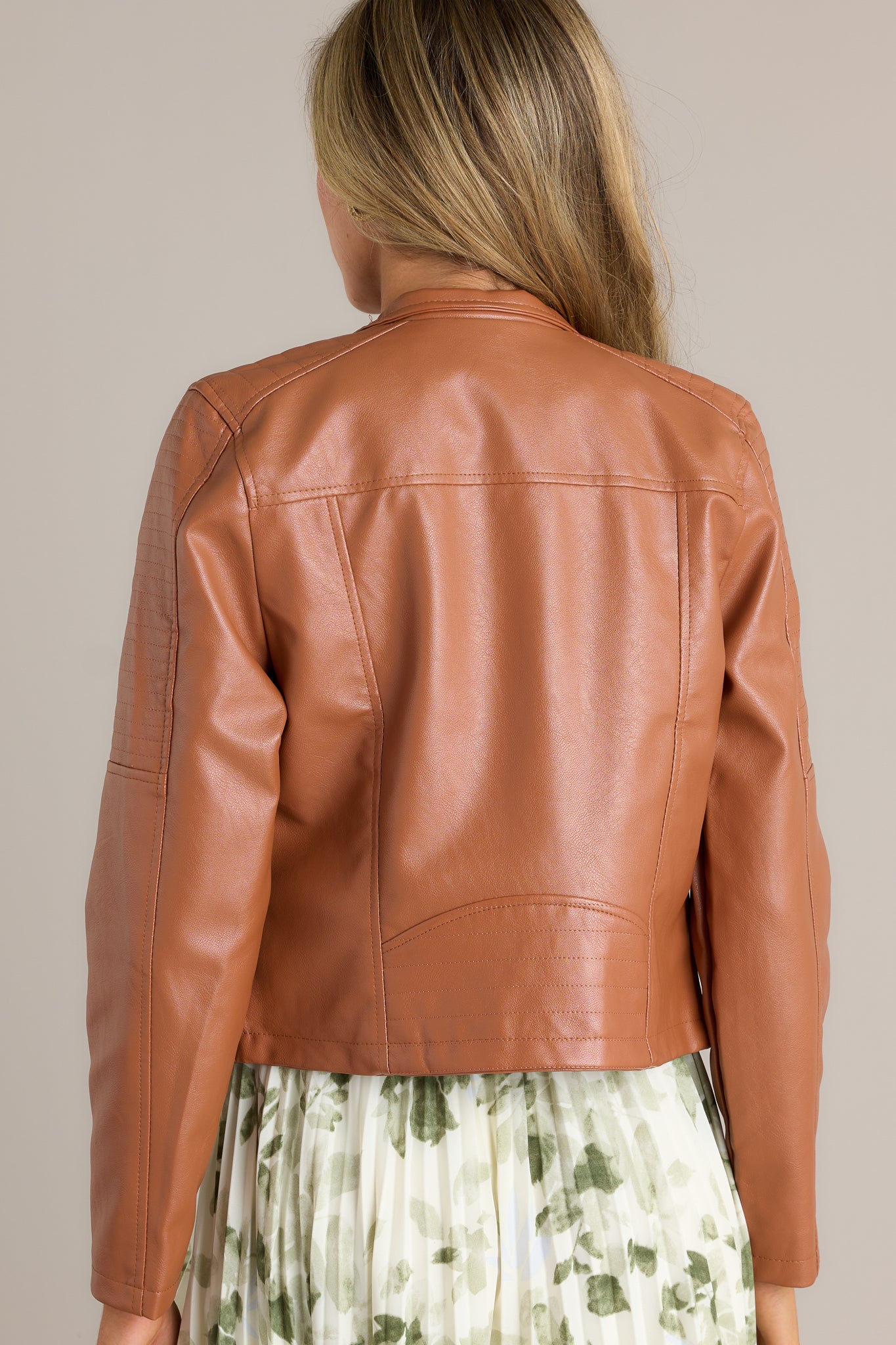 Back view of a moto jacket highlighting the overall fit, stitched detailing on the shoulders, and faux leather finish.