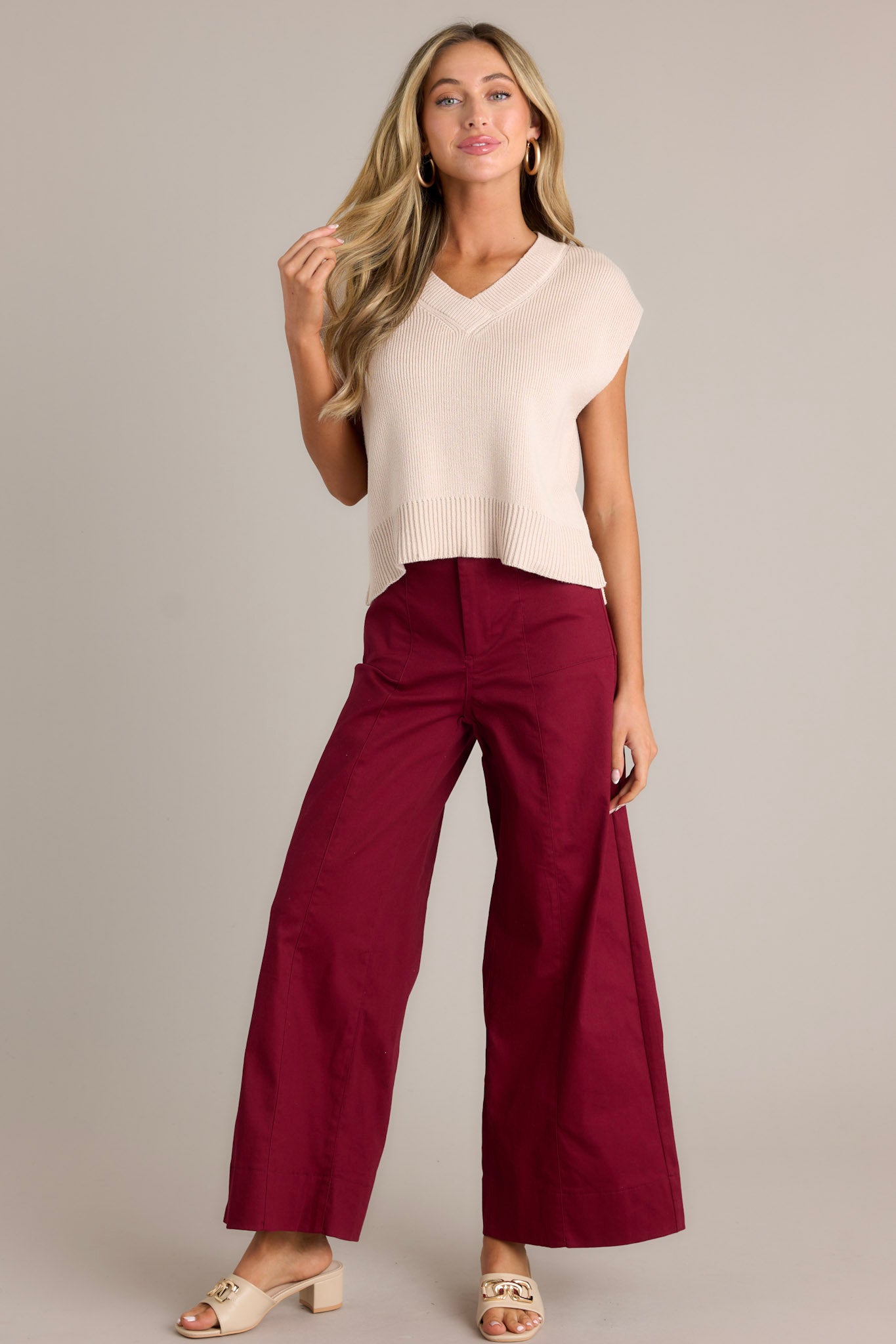 These burgundy pants feature a high waisted design, a button zipper closure, functional rectangular hip pockets and a wide leg.