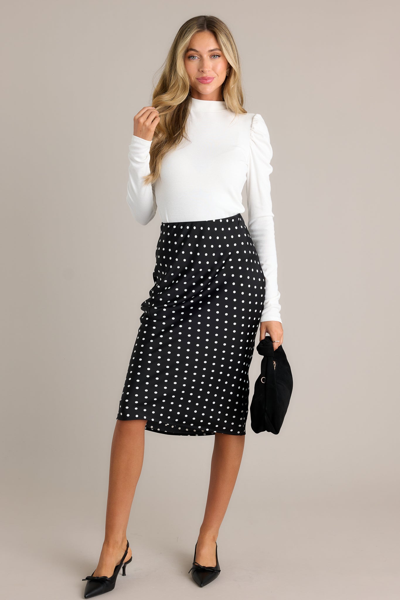 Front view of the black midi skirt showcasing its high-waisted design, elastic waistband, and flattering fit.