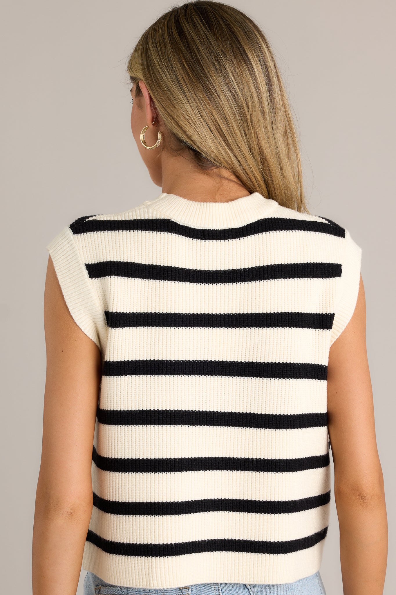 Back view of this sweater top featuring a round neck, a knit material, a classic stripe pattern, a relaxed fit and a sleeveless design.