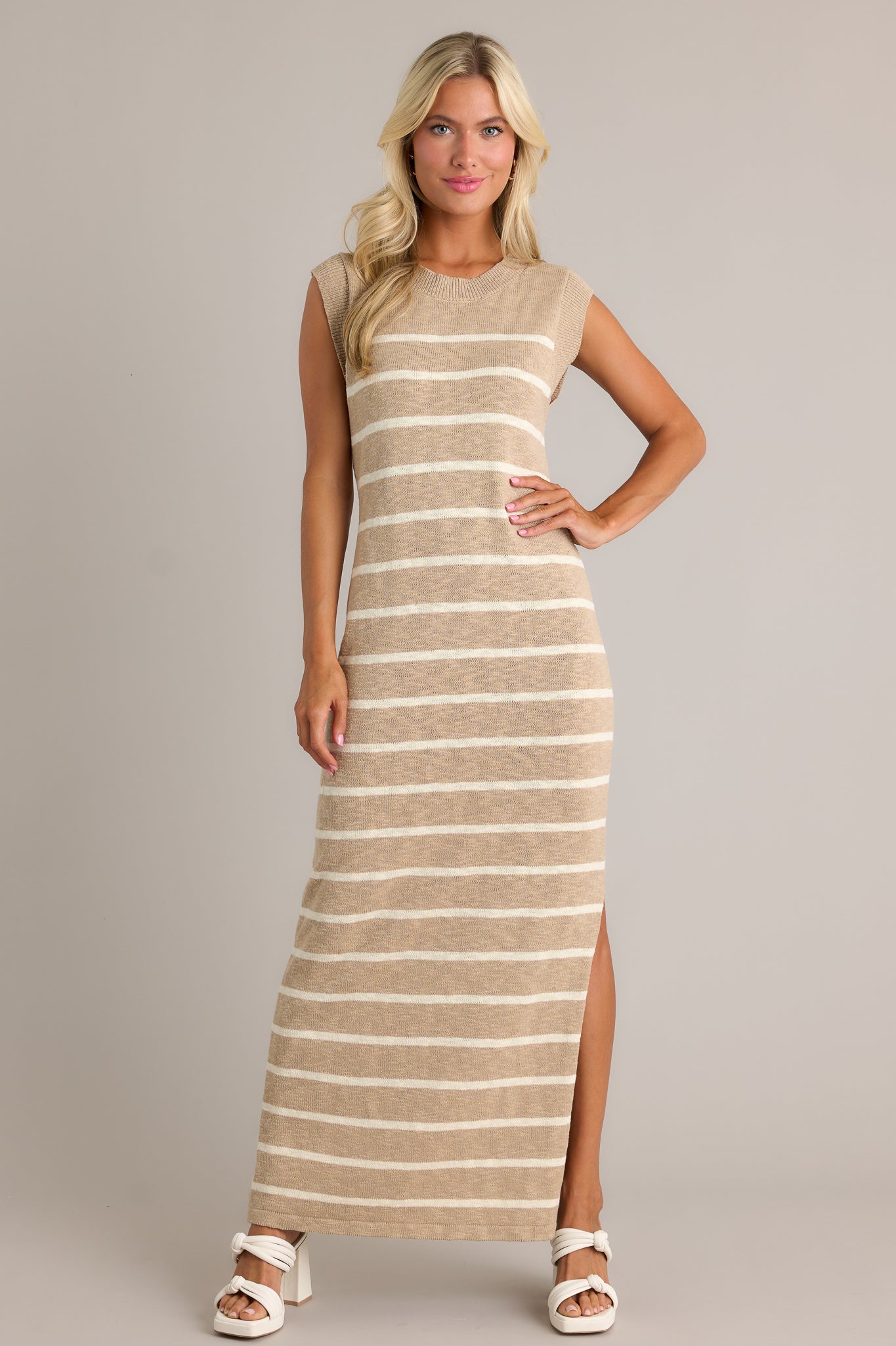 This taupe dress features a ribbed neckline, a small leg slit, and a lightweight knit fabric.