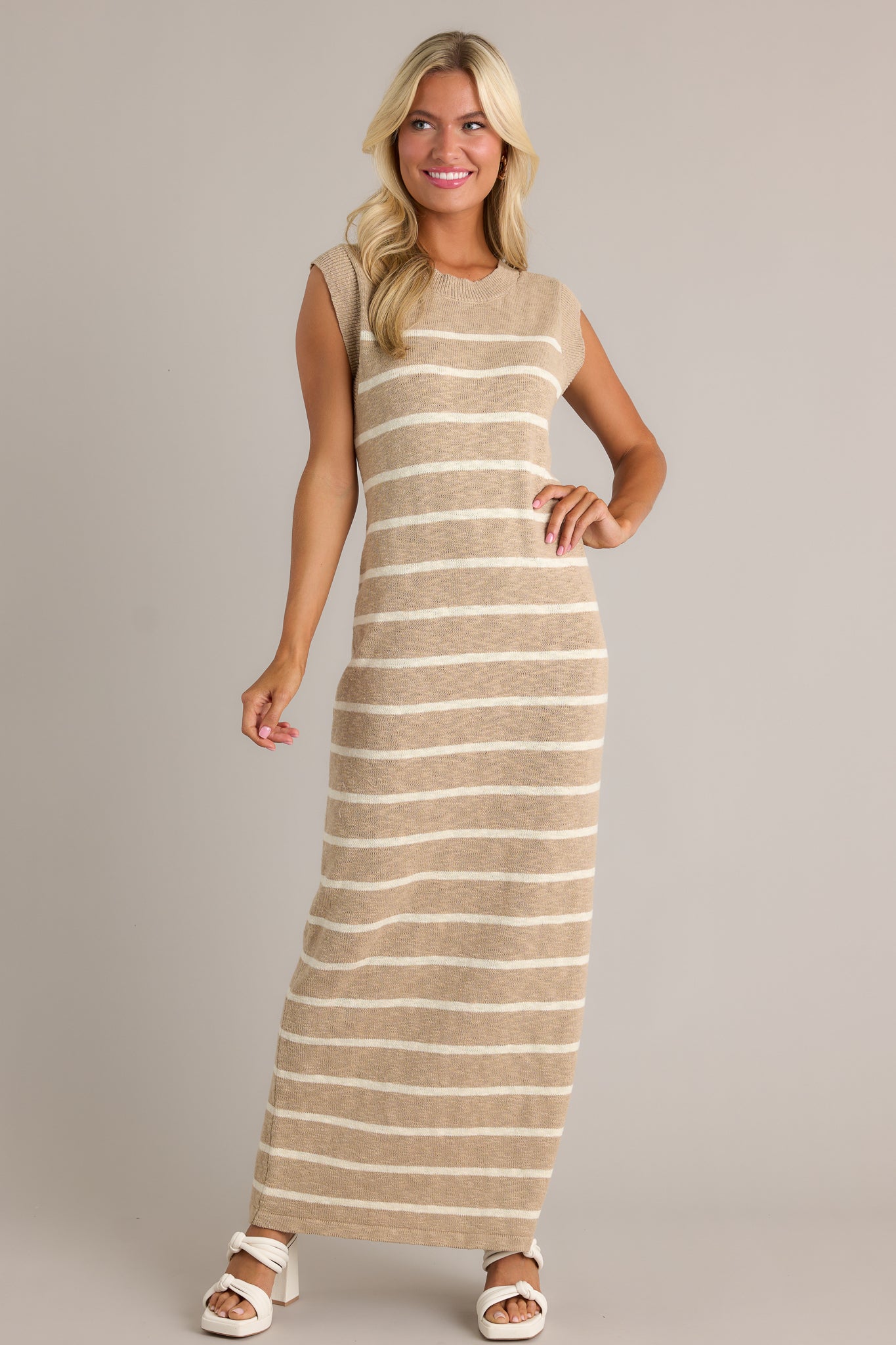 Action shot of a taupe dress displaying the fit and movement, highlighting the ribbed neckline, small leg slit, and lightweight knit fabric.