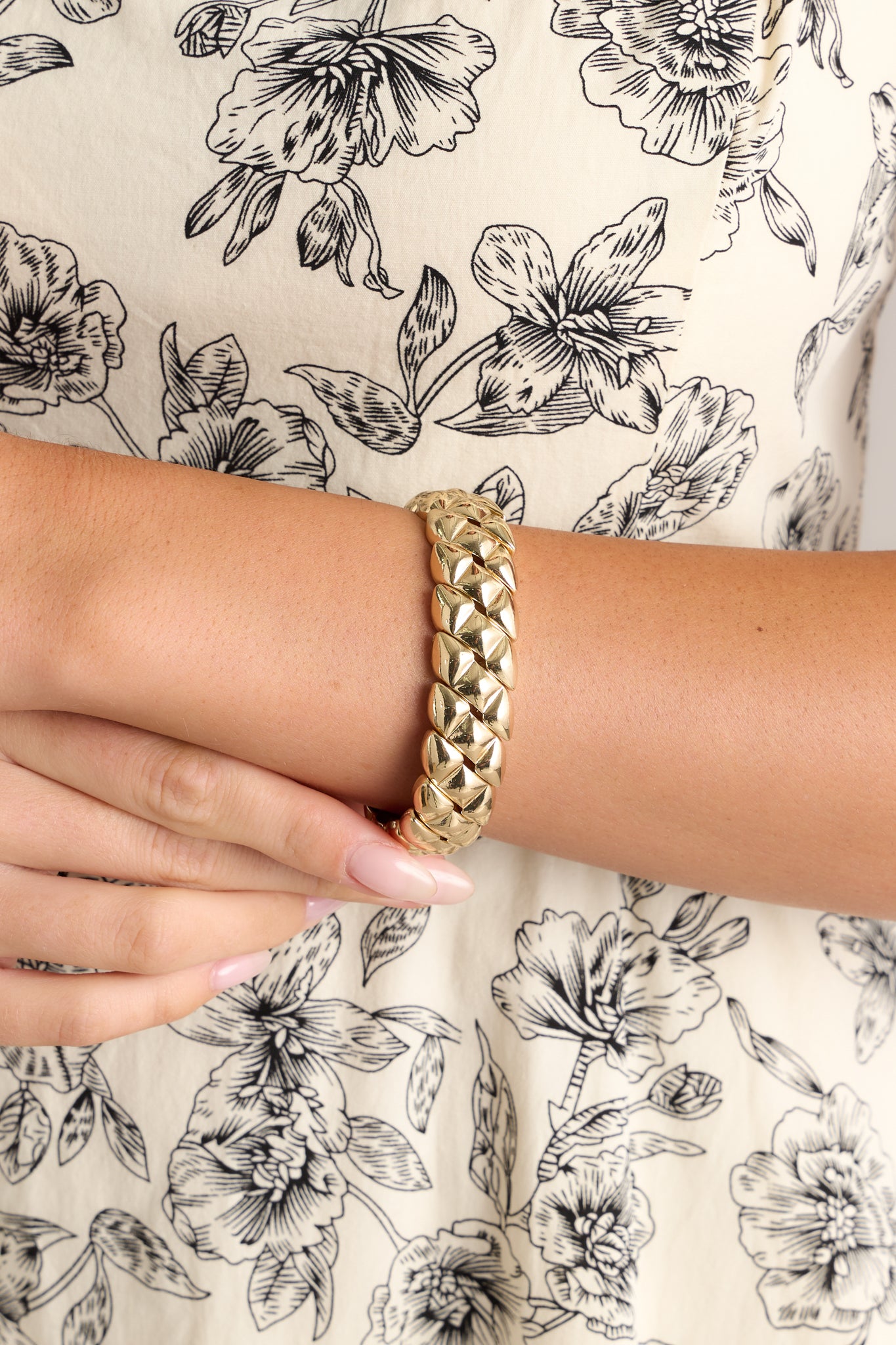 This gold bracelet features elastic bands for stretch as needed, a split design and a snake skin design.