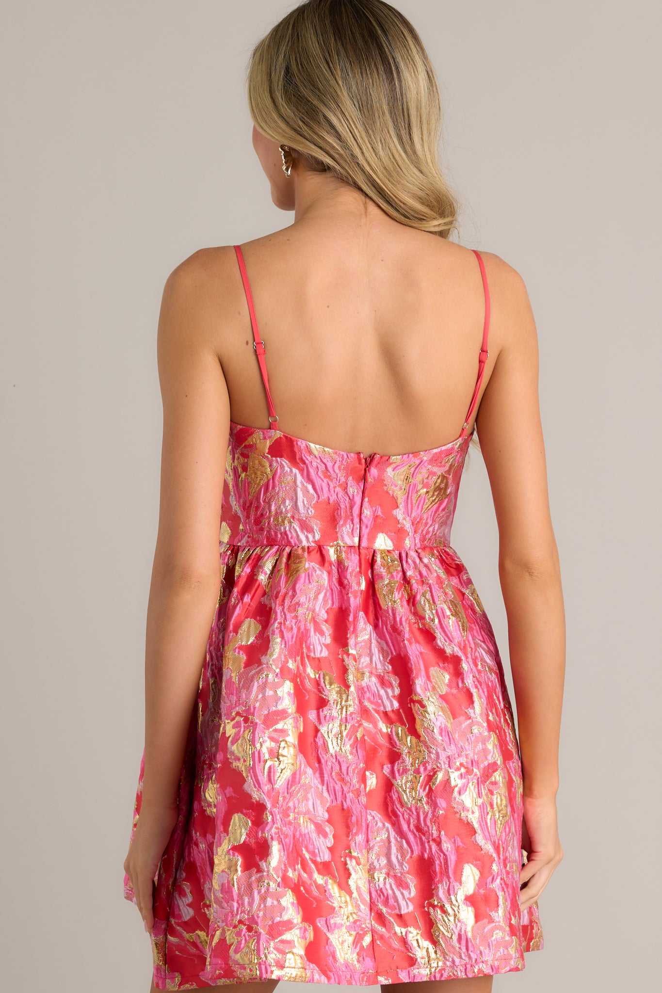 Back view of the pink jacquard dress, highlighting the adjustable straps and the functional zipper closure.