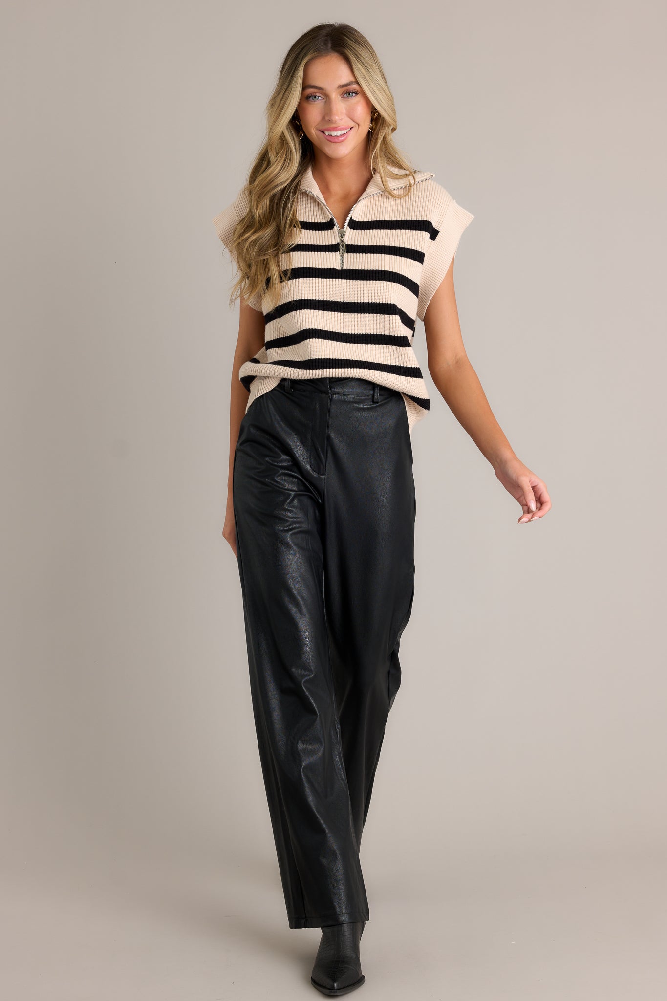 Motion shot of this Ecru top featuring a collared neckline, a functional front zipper, a classic horizontal stripe patter, cap sleeves, a thick hemline and a relaxed fit.