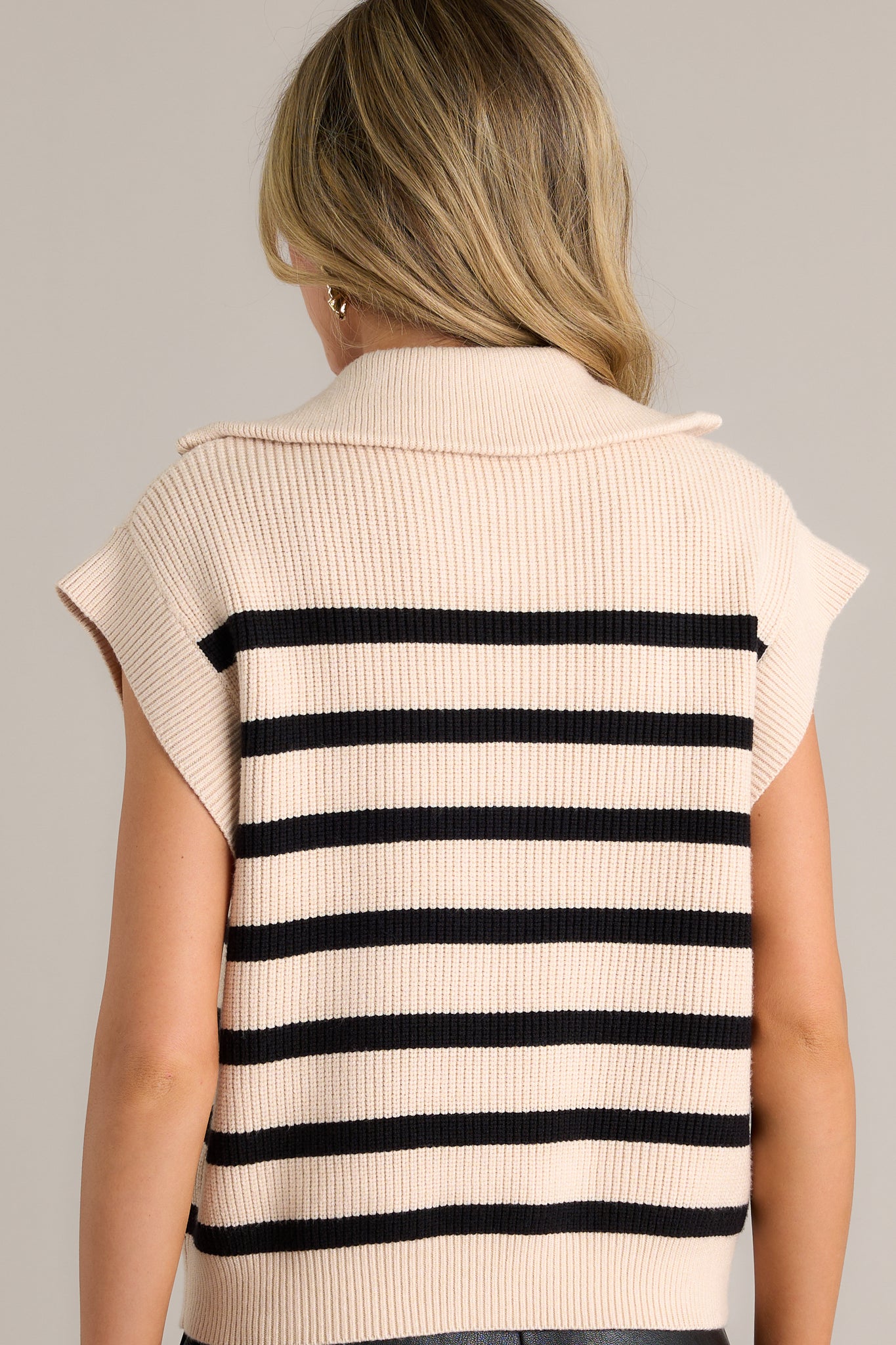 Back view of this Ecru top featuring a collared neckline, a functional front zipper, a classic horizontal stripe patter, cap sleeves, a thick hemline and a relaxed fit.