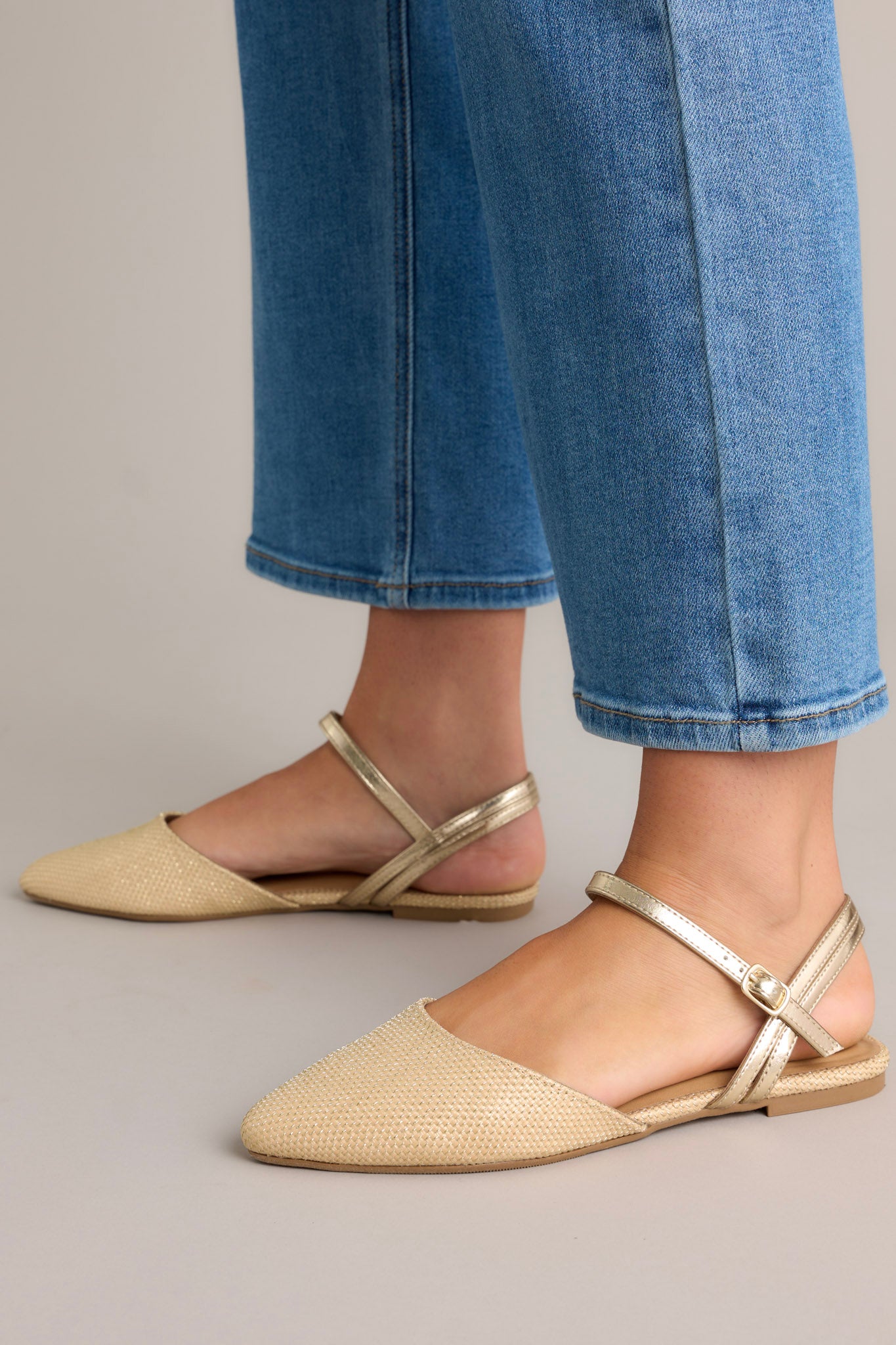 These beige flats feature braided gold detailing, a gold adjustable ankle strap and a cushioned sole.