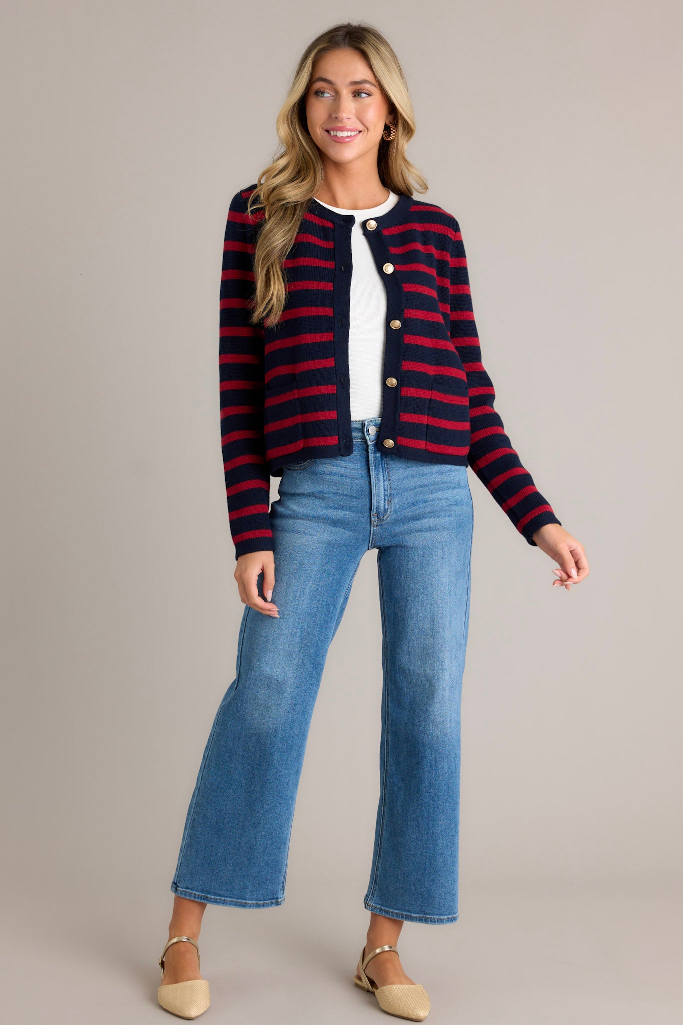 This cardigan features a crew neckline, a full button front, detailed gold buttons, and functional pockets.