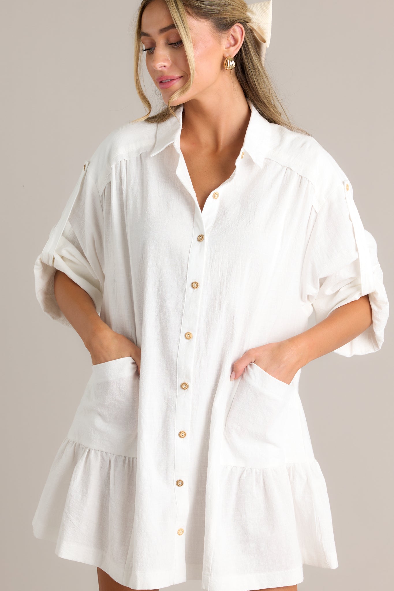 Action shot of a button front dress displaying the fit and movement, highlighting the collared high neckline, functional button front, functional hip pockets, cuffed half sleeves, and tiered design.