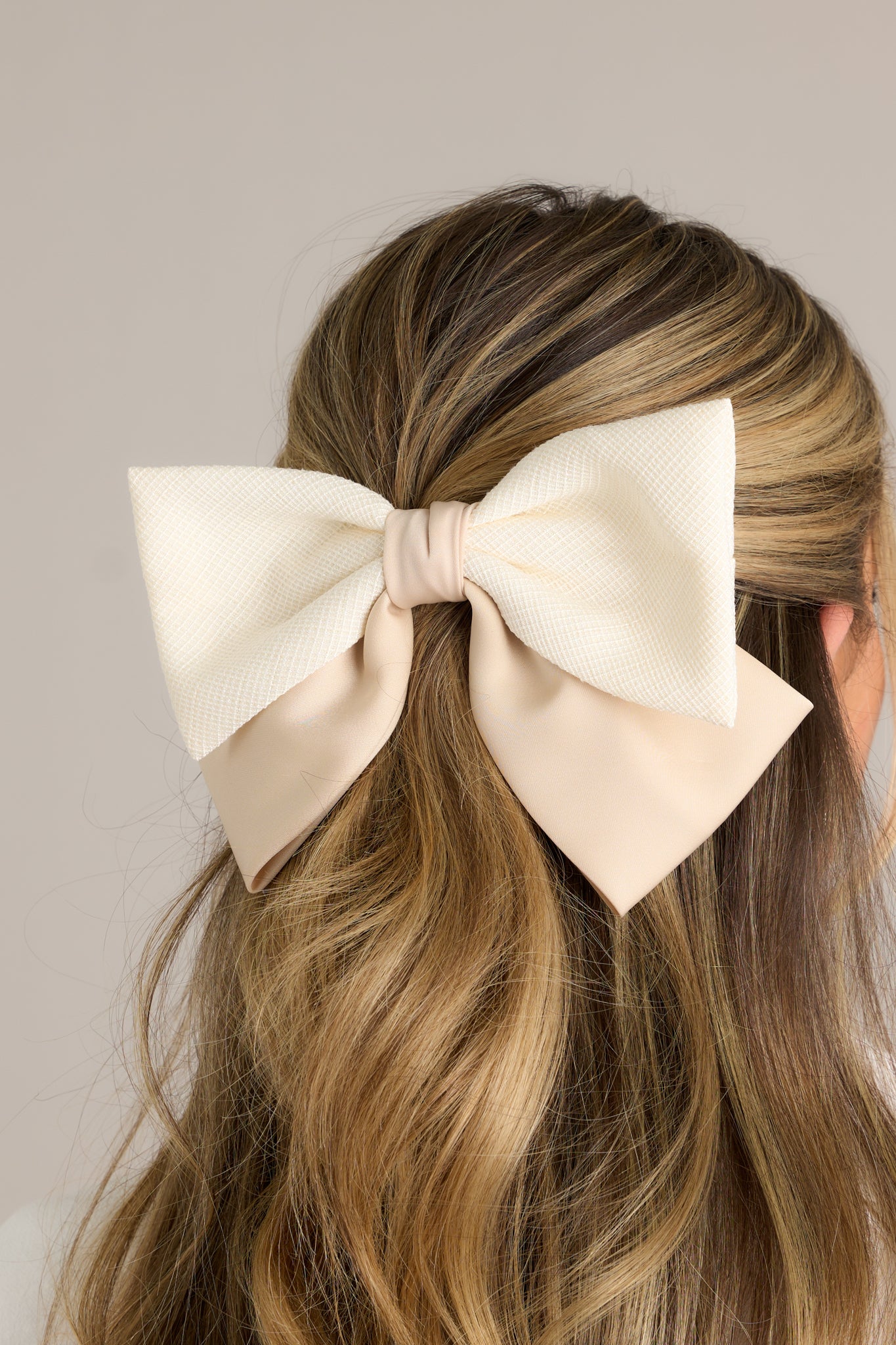 This hair clip features a contrasting beige and ivory fabric and a a barrette clip.