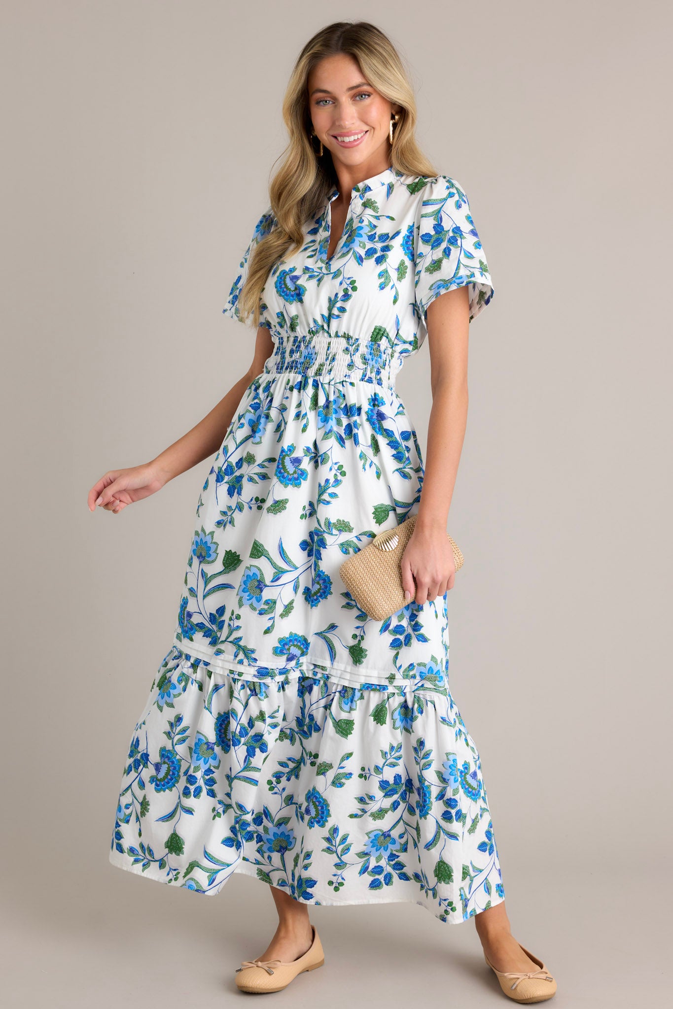 This blue floral dress features a stretchy waistband, small V-neck and blue appliqué florals.