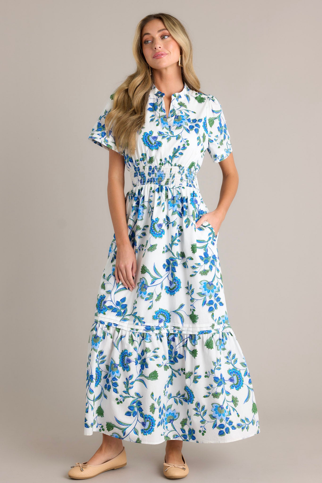 Front view of a blue floral dress featuring a stretchy waistband, a small V-neck, and blue appliqué florals