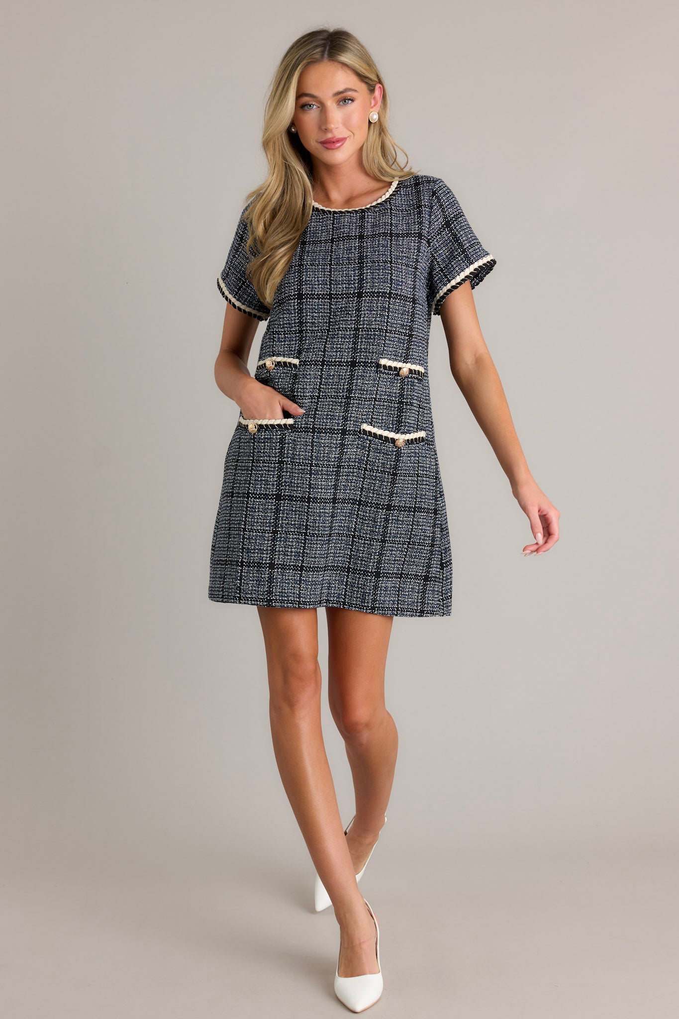 Action shot of a tweed dress displaying the fit and movement, highlighting the rounded neckline, ivory trim, and short sleeves.