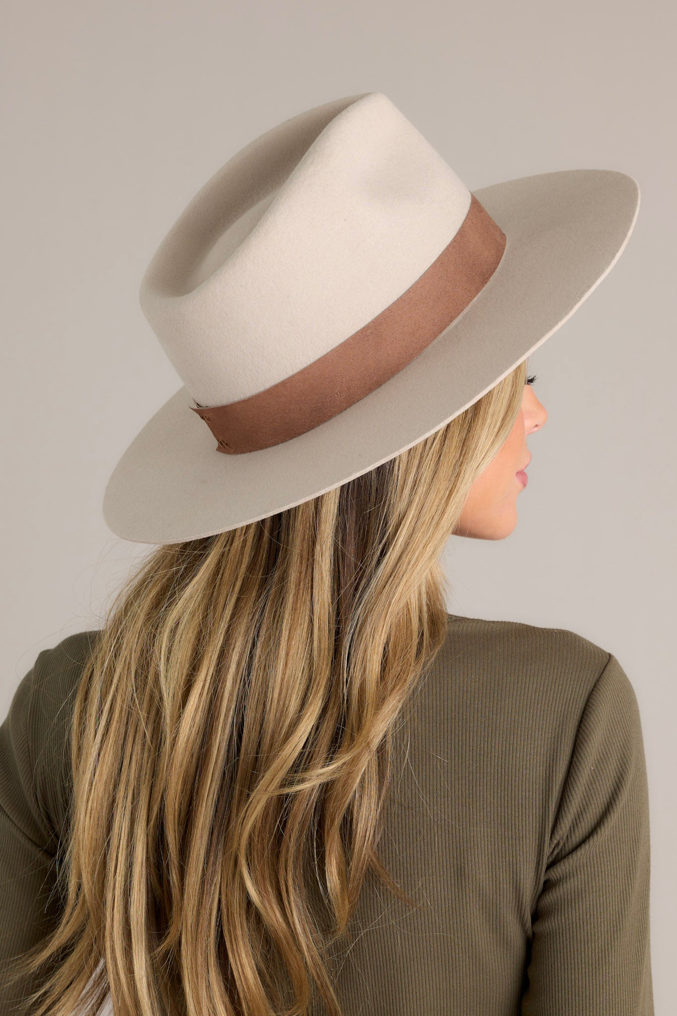 Close-up of this hat that features a flat brim and an attached suede brand.