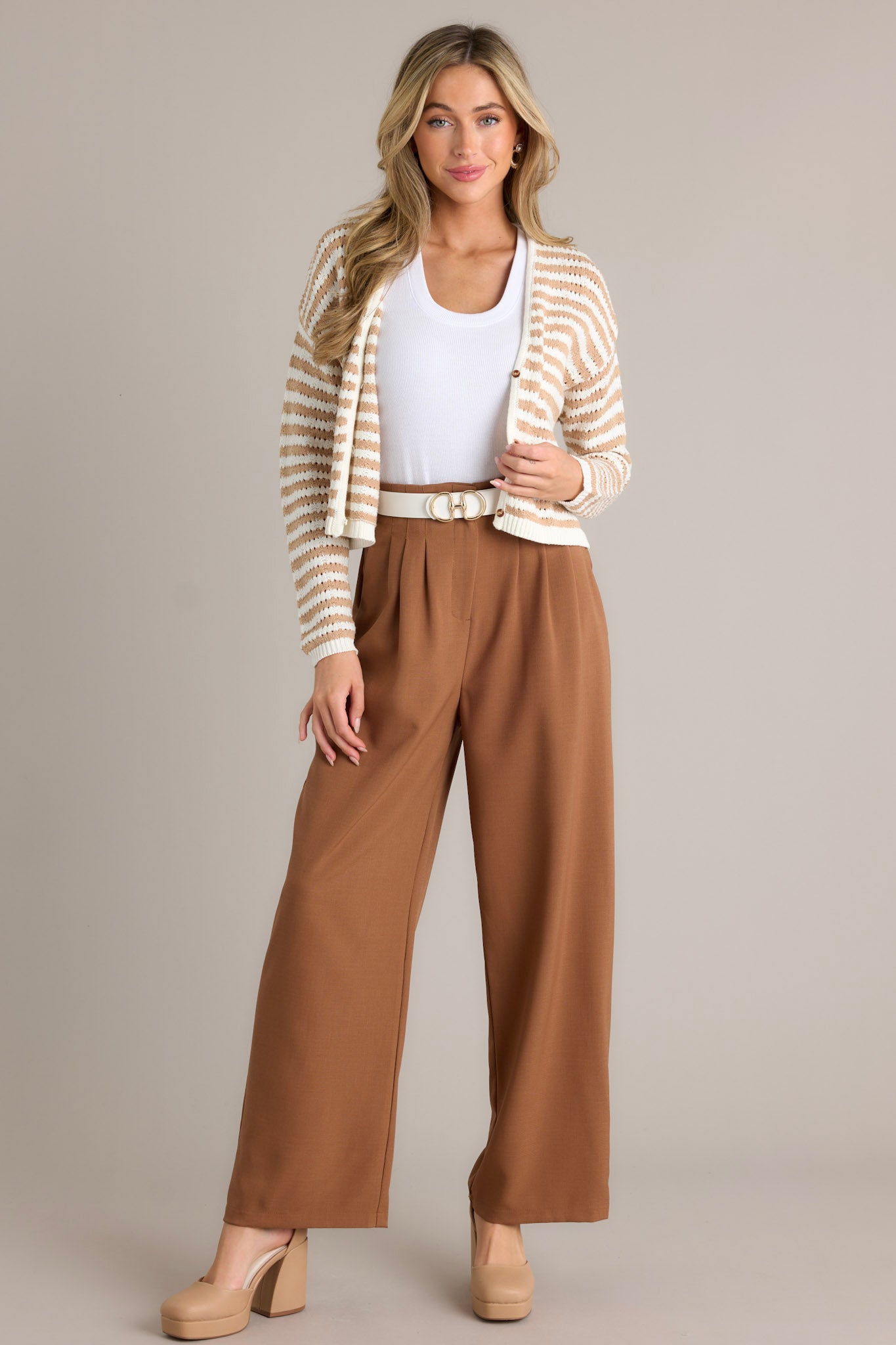 Full body front view of a tan stripe cardigan featuring a v-neckline, functional buttons, an open knit design, a cropped hemline, and ribbed cuffed sleeves.