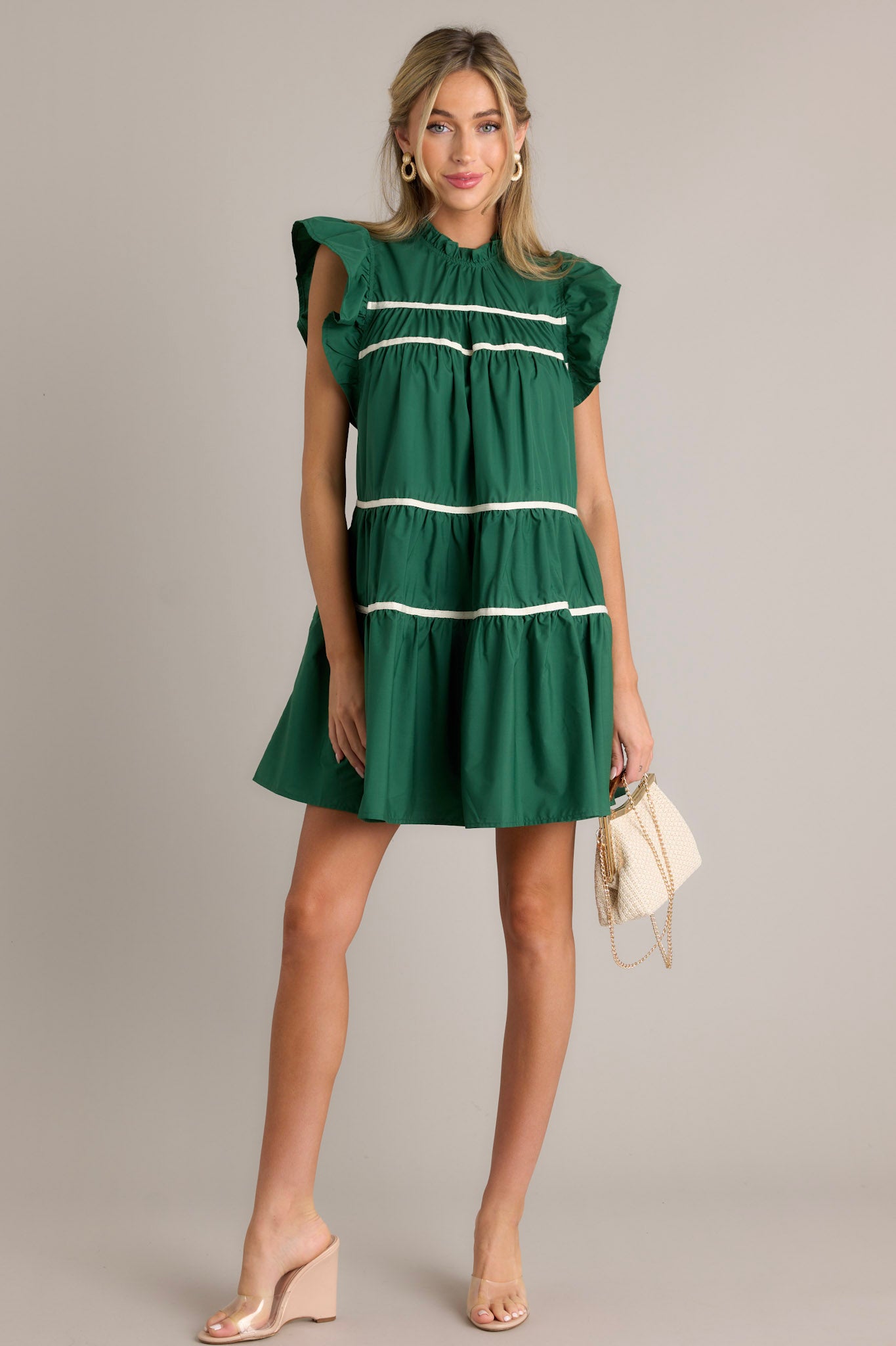 This green dress features ruffled sleeves, a round ruffle neckline, and two functional pockets.