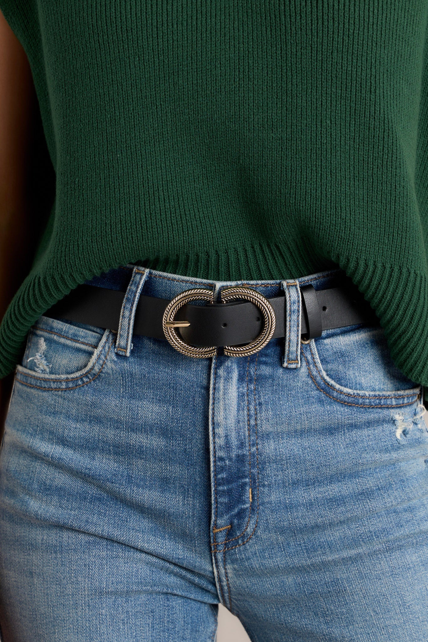 Black belt features a half circle buckle closure, a single prong, a soft exterior, and black gold hardware.