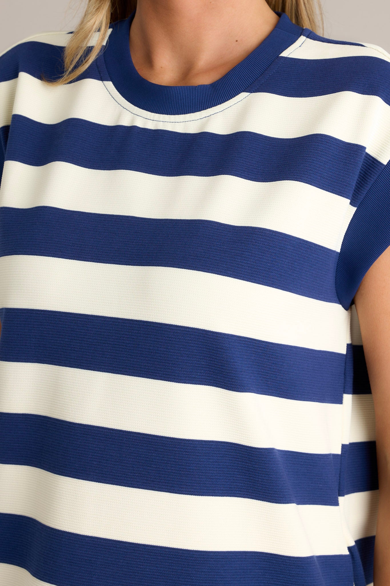 Close up view of this navy stripe mini dress that features a crew neckline, wide cap sleeves, functional hip pockets, and a relaxed fit.