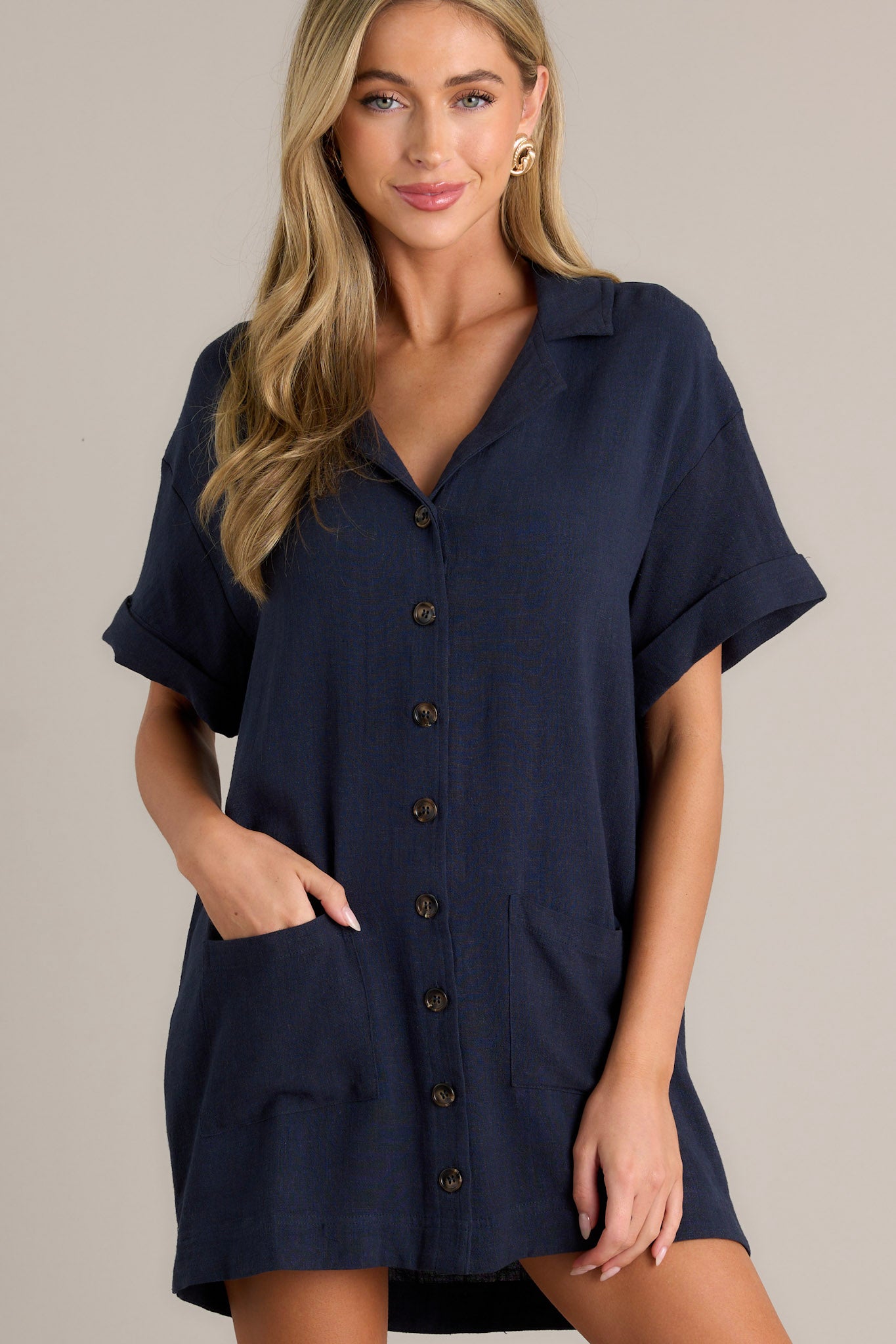 Stylish navy dress with short sleeves, a collared neckline, functional buttons, and pockets for a laid-back vibe.