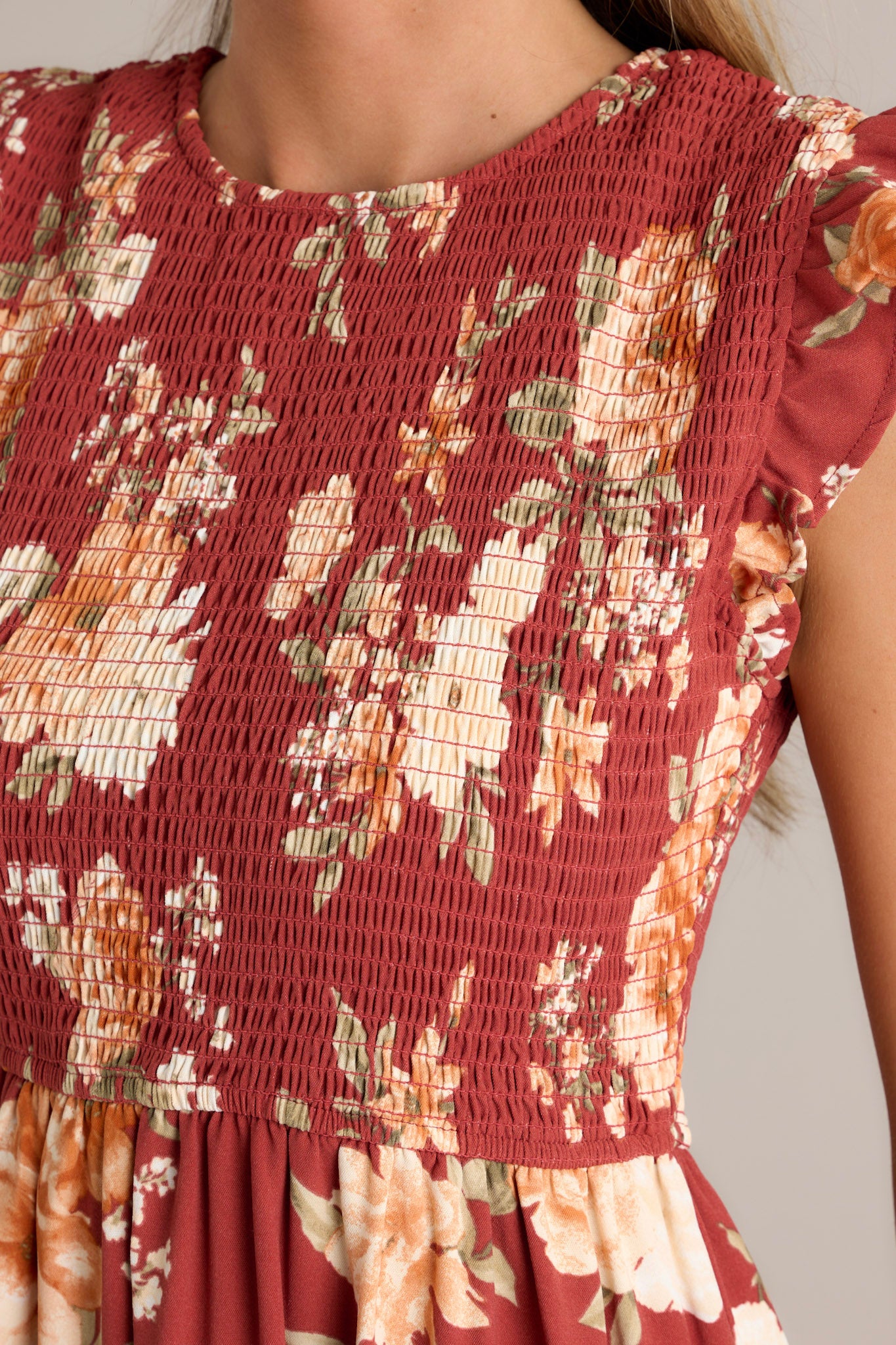 Close-up of the red dress focusing on the fully smocked bodice, the ruffle detailing on the short sleeves, and the texture of the tiered skirt